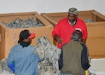Navy veteran and volunteer, Steven Adams, hands out excess property from DLA Disposition Services to two homeless veterans in Battle Creek, Michigan.