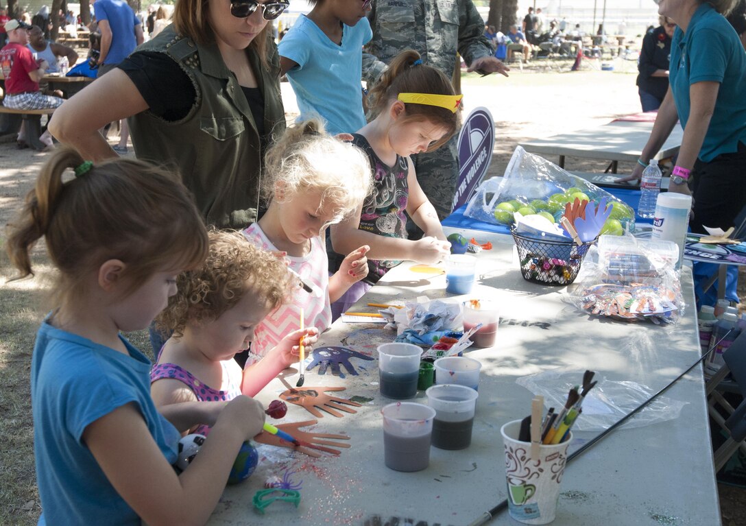 Kids decorate paper hands during the 301st Fighter Wing Family Day, Oct. 1, 2016 at Naval Air Station Fort Worth Joint Reserve Base, Texas. Wing members and families participated in the "I Can, We Can" project by decorating hands and writing personal pledges on them to encourage others and themselves to stand up to domestic violence. The project focuses on the impact individuals can make in the fight against all forms of interpersonal violence. (U.S. Air Force photo by Tech. Sgt. Melissa Harvey)