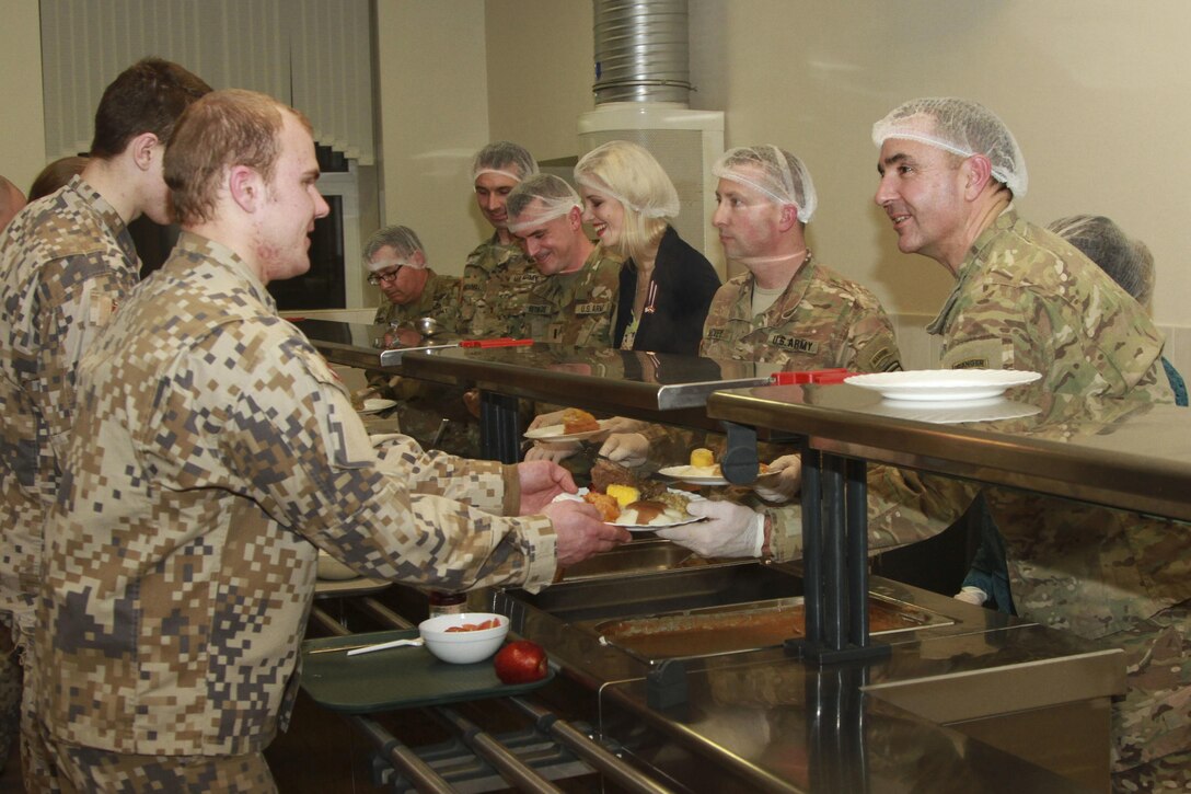 Army Col. Greg Anderson serves a Latvian soldier during Thanksgiving dinner at Camp Adazi, Latvia, Nov. 22, 2016. Anderson is the commander of the 173rd Airborne Brigade. Army photo by Sgt. Lauren Harrah