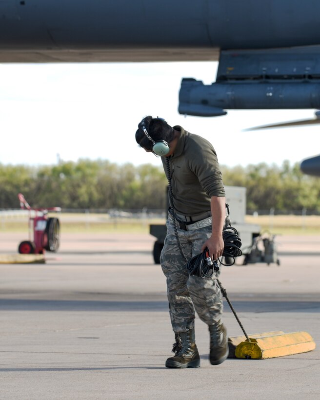 U.S. Air Force Staff Sgt. Kevin Khanthavongsay, 489th Maintenance Squadron B-1B Lancer crew chief, pulls a set of chocks from a B-1 at Dyess Air Force Base, Texas, Nov. 22, 2016. The chocks are used to hold the front wheels of the aircraft in place for safety precautions. (U.S. Air Force photo by Senior Airman Kedesha Pennant)

