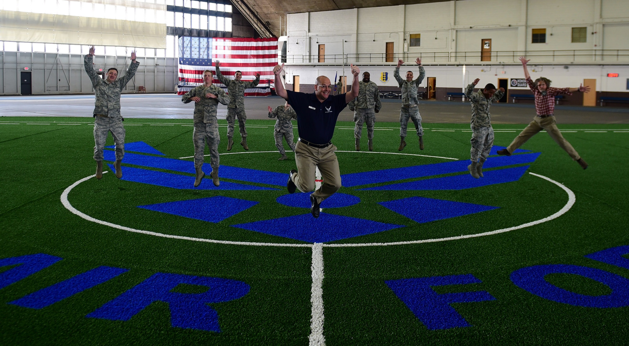 Members from the 28th Civil Engineer Squadron, 28th Contracting Squadron and 28th Force Support Squadron jump for joy inside the Pride Hangar at Ellsworth Air Force Base S.D., Nov. 21, 2016. Over the past month, members of the three squadrons completed a $249,000 renovation project and the facility is ready for use. (U.S. Air Force photo by Airman 1st Class James L. Miller)
