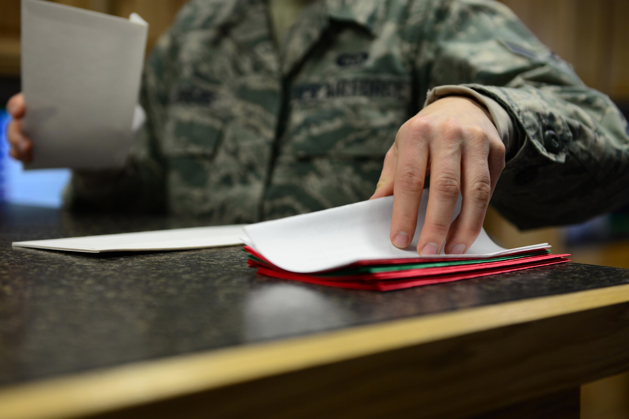 U.S. Air Force Airman 1st Class Lisa Rogers, a 354th Operations Support Squadron weather forecaster apprentice, reaches for a letter Nov. 22, 2016, at Eielson Air Force Base, Alaska. Rogers and the weather flight send out hundreds of letters from Santa each year to children all around the world as part of the “Santa’s Mailbag” program which started more than 60 years ago. (U.S. Air Force photo by Airman 1st Class Cassandra Whitman)
