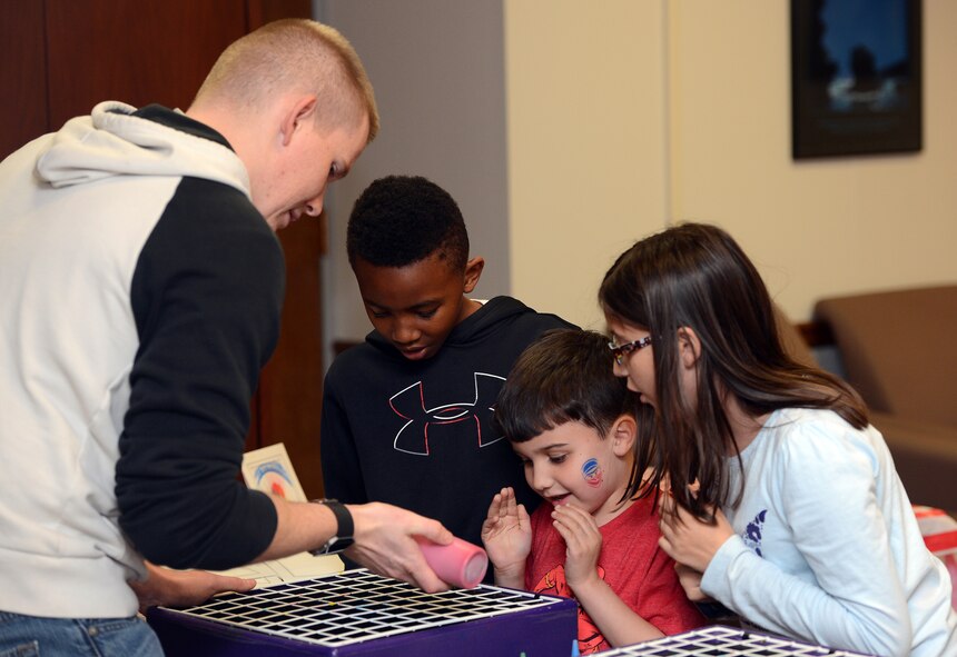 Staff Sgt. James Ratzlaff (left), 62nd Comptroller Squadron financial services technician, conducts spin art for children of Airmen at the Hearts Apart dinner Nov. 17, 2016 at Joint Base Lewis-McChord, Wash. Activities for children included spin art, carnival games and free cotton candy and popcorn. (U.S. Air Force photo/Senior Airman Jacob Jimenez)  
