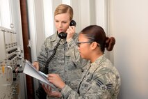 From left Staff Sgt. Caitlin Gillaspie and Senior Airman Erika Santos, 5th Bomb Wing command post emergency actions officers, use a secure radio at Minot Air Force Base, N.D., Nov. 16, 2016. The Minot Command Post is the command and control link between our nation's highest leaders, such as the president, secretary of Defense, Air Force Global Strike Command and our wings' senior leaders. (U.S. Air Force photo/Airman 1st Class Jessica Weissman)