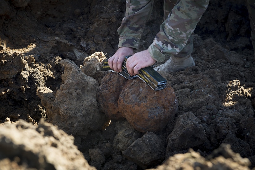 Senior Airman Dillon Babb, 628th Civil Engineer Squadron explosive ordnance disposal technician applies C4 explosive strips to Civil War-era cannonballs here. The 628th CES EOD flight worked with local emergency management teams to safely dispose of explosives brought ashore by the tides of Hurricane Matthew in October. 