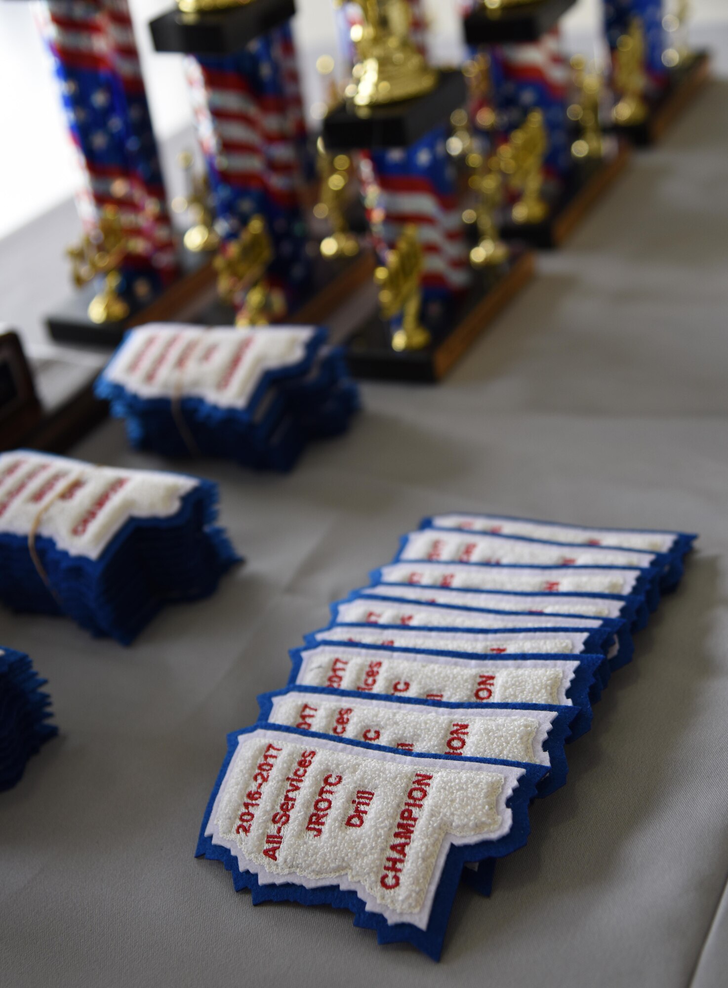 Patches and trophies sit on display during the Third Annual Mississippi All-Services Junior ROTC Drill Competition Nov. 18, 2016, on Keesler Air Force Base, Miss. More than 500 Junior ROTC cadets, spectators and volunteers were in attendance where cadets battled for the best all-services Junior ROTC team in Mississippi. Seventeen Junior ROTC teams from all military branches were represented at the event with the Biloxi High School Air Force Junior ROTC earning the top honors. (U.S. Air Force photo by Kemberly Groue)