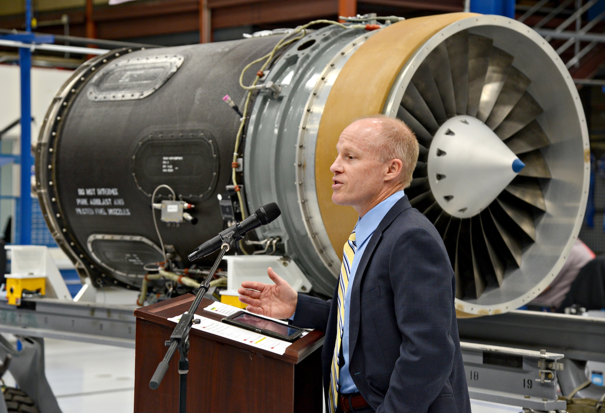 Phil Burkholder, president of Defense North America, Rolls-Royce, speaks on behalf of his company during the ribbon cutting ceremony for the new F137 engine maintenance line in Bldg. 3221. (Air Force photo by Kelly White)