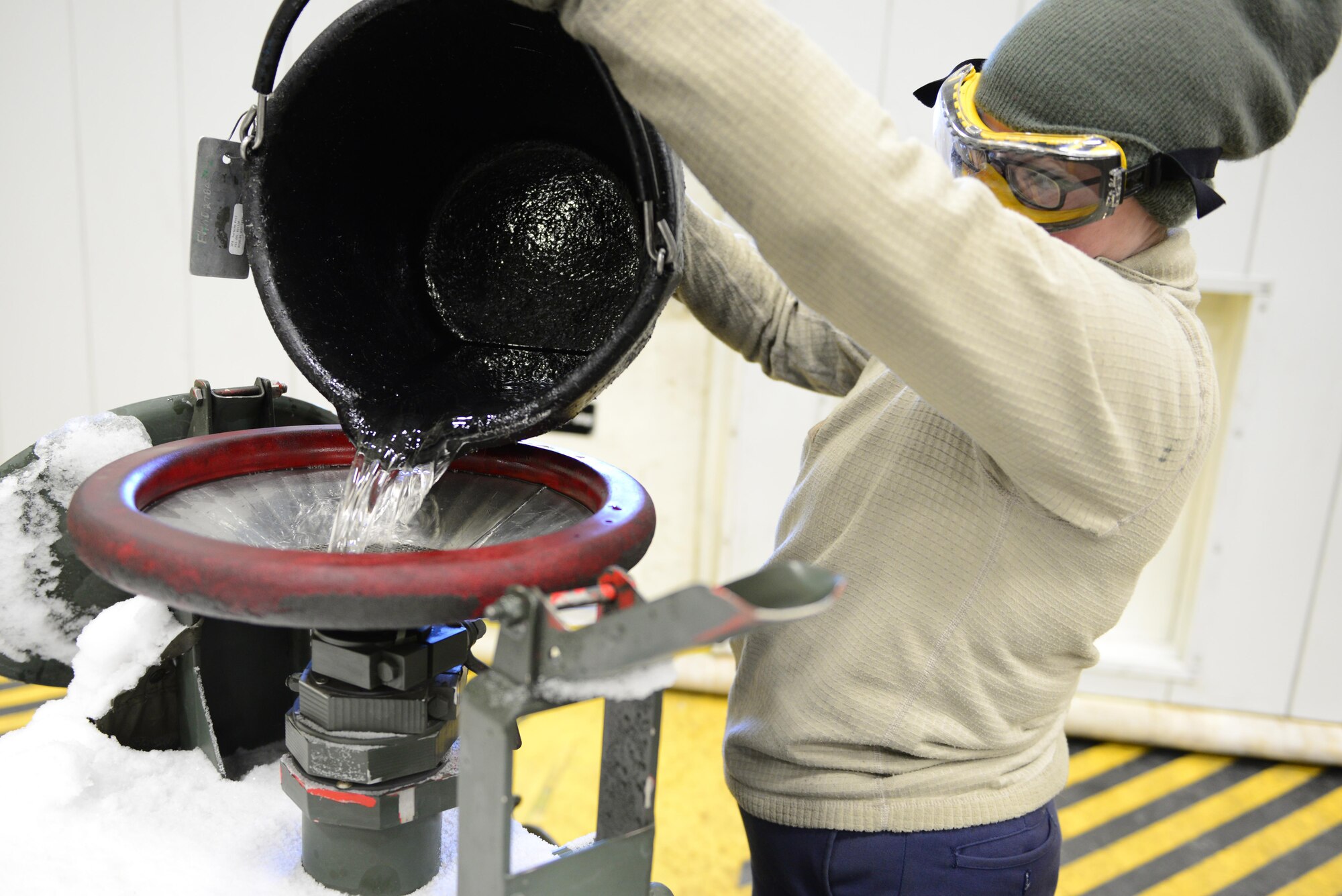 U.S. Air Force Senior Airman Jerri Addison, a 354th Aircraft Maintenance Squadron crew chief, empties a bucket of fuel into a tank Nov. 22, 2016, at Eielson Air Force Base, Alaska. Addison was emptying an F-16 Fighting Falcon fuel tank for maintenance. (U.S. Air Force photo by Airman Eric M. Fisher)