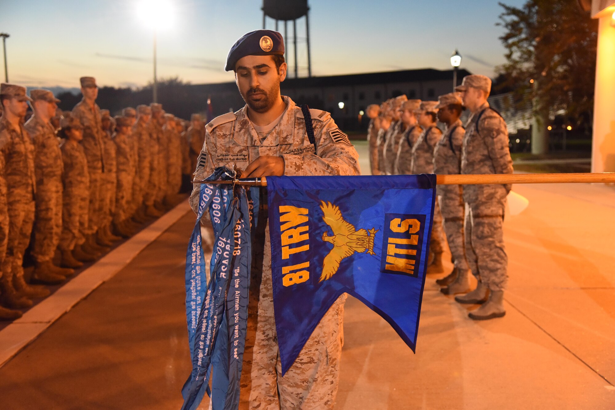 International student Master Sgt. Abdullah Al Qahtani adds a ribbon to a streamer to the 81st Training Wing Military Training Leadership schoolhouse flag during a MTL graduation ceremony at Keesler Air Force Base, Miss., Nov. 18, 2016. The graduating students were the first class to attend the revised MTL course which includes Human Behavior and the Profession of Arms Center of Excellence training. (U.S. Air Force photo by Kemberly Groue)