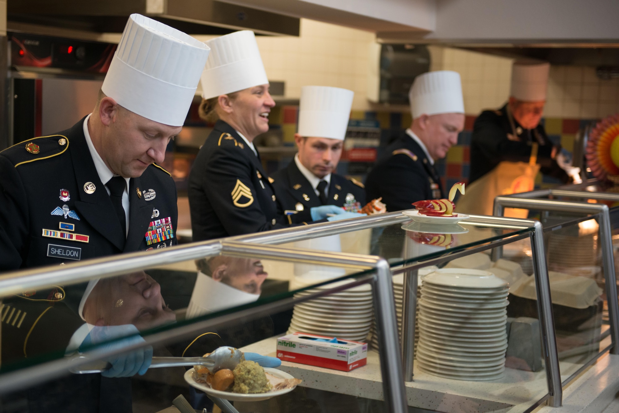 Sergeant Major Ron Sheldon, 673d Air Base Wing senior enlisted advisor serves up a dish loaded with food to a Joint Base Elmendorf-Richardson Soldier Nov 23 at the Wilderness Inn Dining Facility. As a matter of tradition, every year, base leadership serve the Soldiers and Airmen of JBER a thanksgiving meal. 