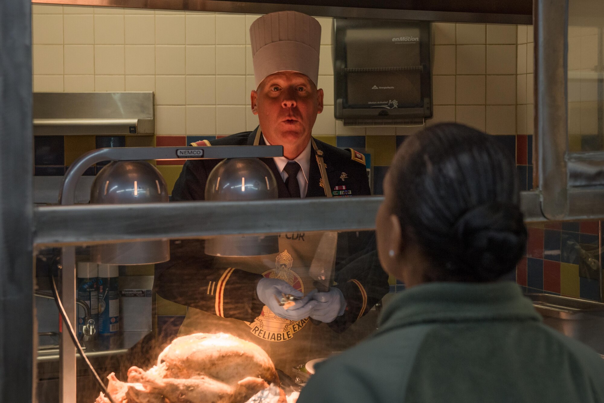 Army Lt. Col. John Gavin, 17th Combat Support Sustainment Battalion commander carves up some turkey for an Airman at the Wilderness Inn Dining Facility on Joint Base Elmendorf-Richardson, Alaska Nov. 23. As a matter of tradition, every year, base leadership serve the Soldiers and Airmen of JBER a thanksgiving meal. 