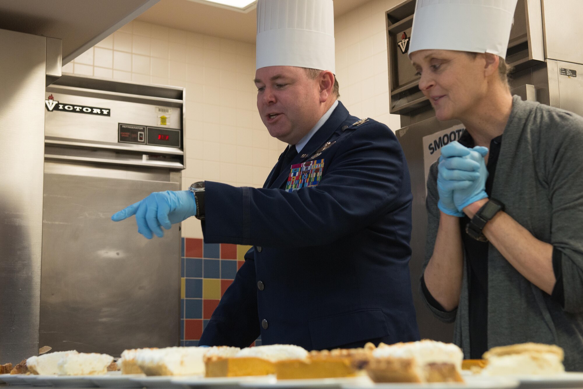 Air Force Col. Hubert, 11th Air Force vice commander and his wife, Jill man the dessert station at the Wilderness Inn Dining Facility on Joint Base Elmendorf-Richardson, Alaska Nov 23. As a matter of tradition, every year, base leadership serve the Soldiers and Airmen of JBER a thanksgiving meal. 