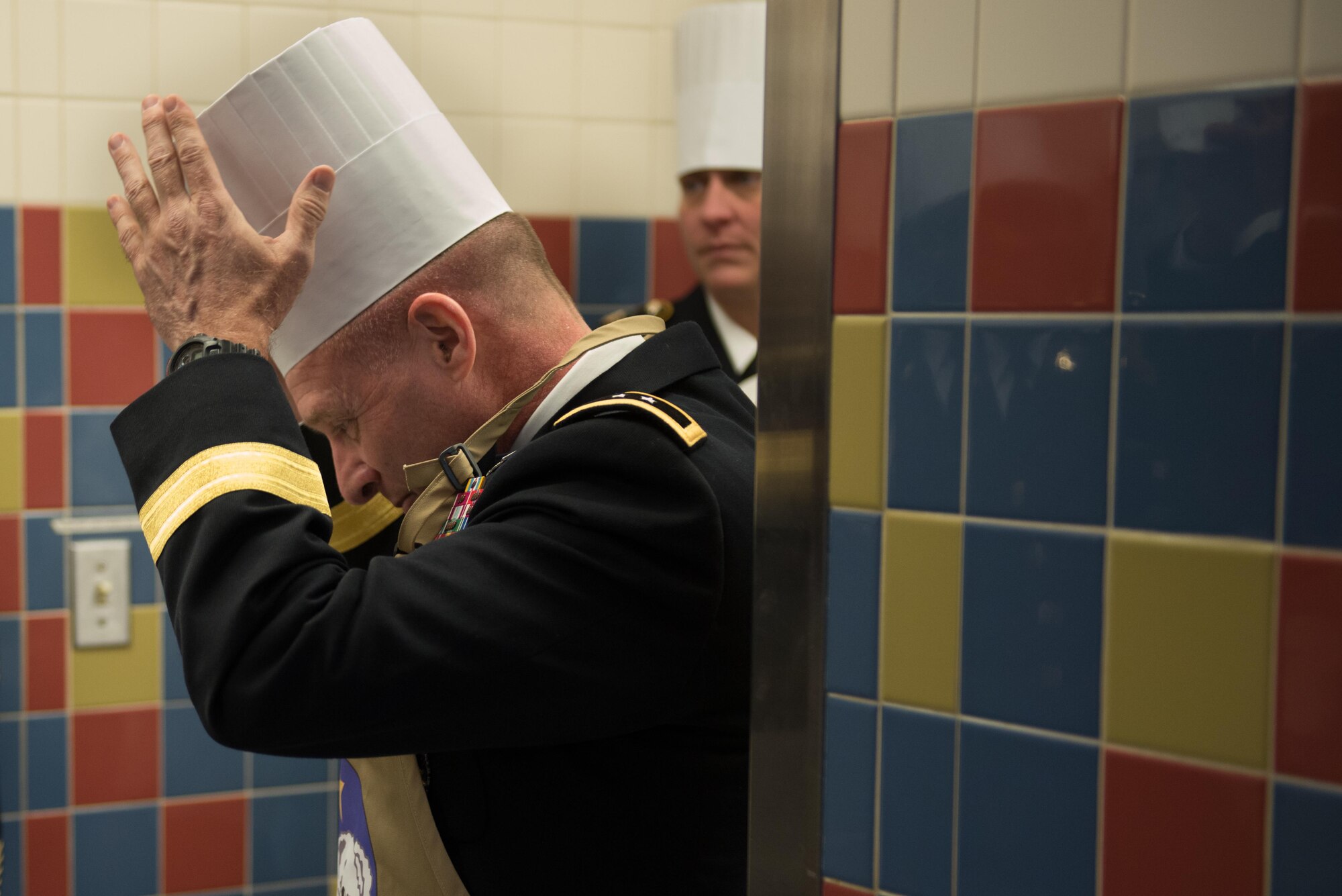 Army Maj. Gen. Bryan Owens, United States Army Alaska commander adjusts his chef's hat at the Wilderness Inn Dining Facility on Joint Base Elmendorf-Richardson, Alaska, Nov. 23. As a matter of tradition, every year, base leadership serve the Soldiers and Airmen of JBER a thanksgiving meal.