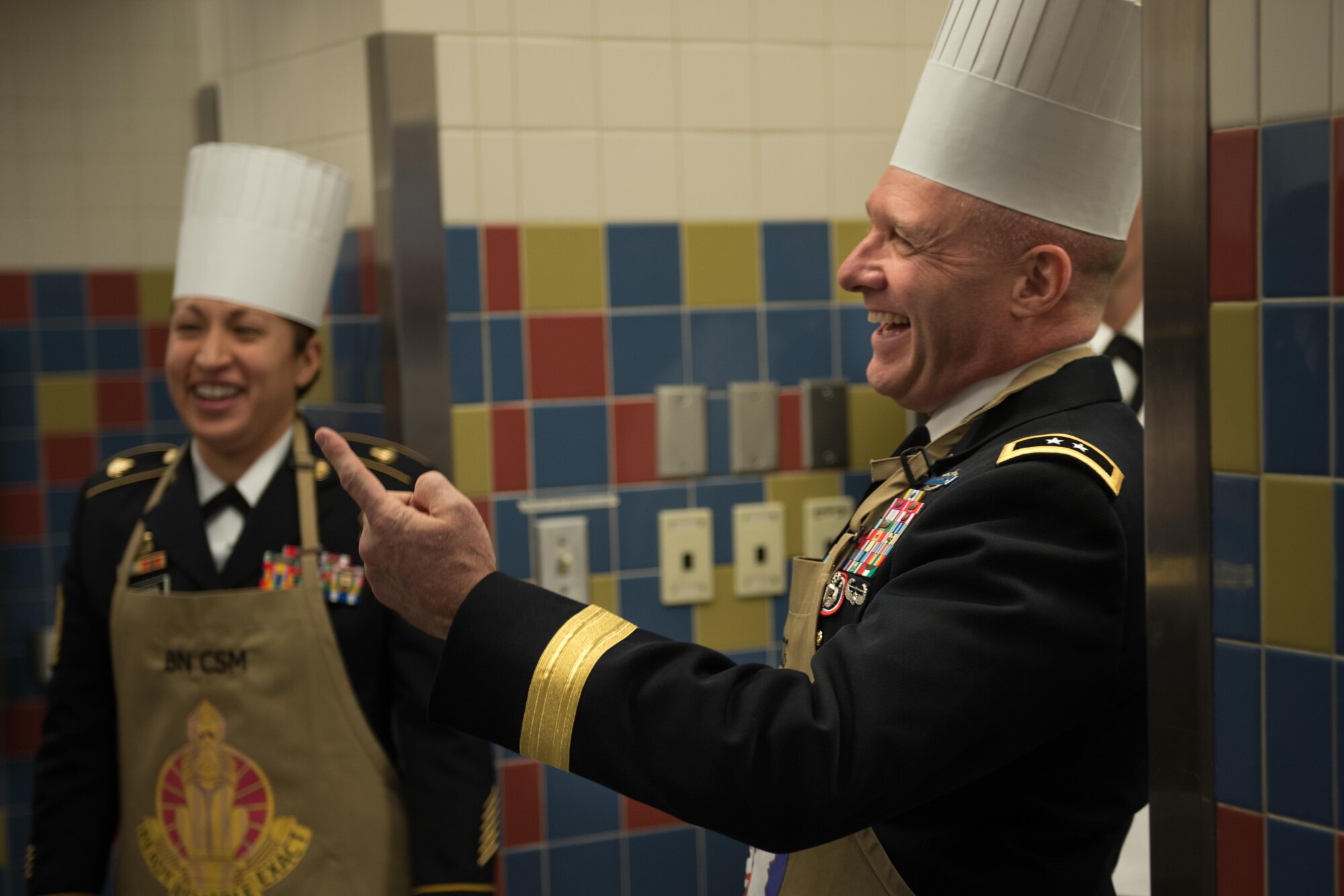 Army Maj. Gen. Bryan Owens, United States Army Alaska commander, laughs as he gestures toward his chef's hat Nov. 23 in the Wilderness Inn Dining Facility on Joint Base Elmendorf-Richardson, Alaska. As a matter of tradition, every year, base leadership serve the Soldiers and Airmen of JBER a thanksgiving meal.