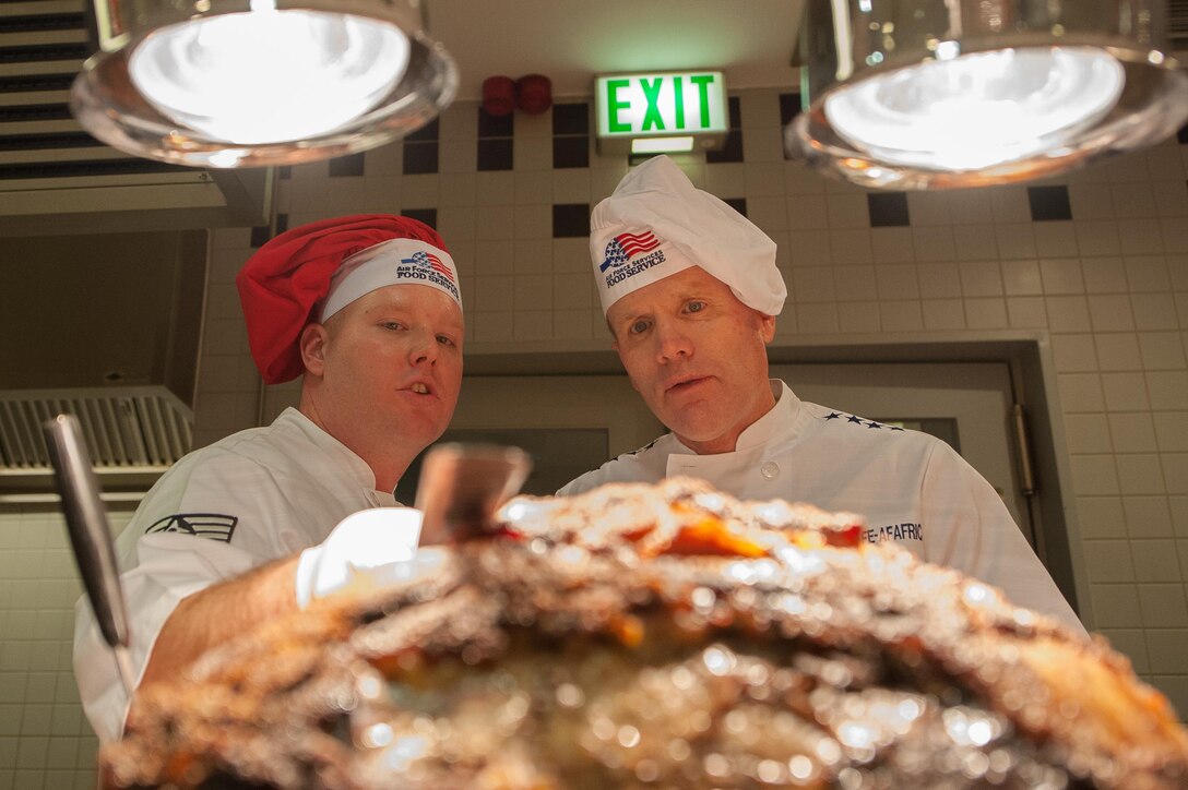 Gen. Tod D. Wolters, U.S. Air Forces in Europe and Air Forces Africa commander, talks with Staff Sgt. Shane Farkas, 786th Force Support Squadron Rheinland Inn Dining Facility production manager, as they prepare meals for Airmen during a Thanksgiving lunch at Ramstein Air Base, Germany, Nov. 24, 2016. The event was open to all DoD ID card holders, retirees and family members. Senior leaders serving meals on Thanksgiving to Airmen and their families is a longstanding tradition that allows them to spend time with servicemembers during the holiday. In the U.S., the modern Thanksgiving holiday tradition can trace its origins back to 1621 in the heart of a newly-founded city called Plymouth in present-day Massachusetts. However, the first nationwide Thanksgiving proclamation was made by the first president of the U.S., George Washington, in 1789. Since then, the holiday has been celebrated by an entire nation to recount the blessings of the year. (U.S. Air Force photo by Airman 1st Class Lane T. Plummer)