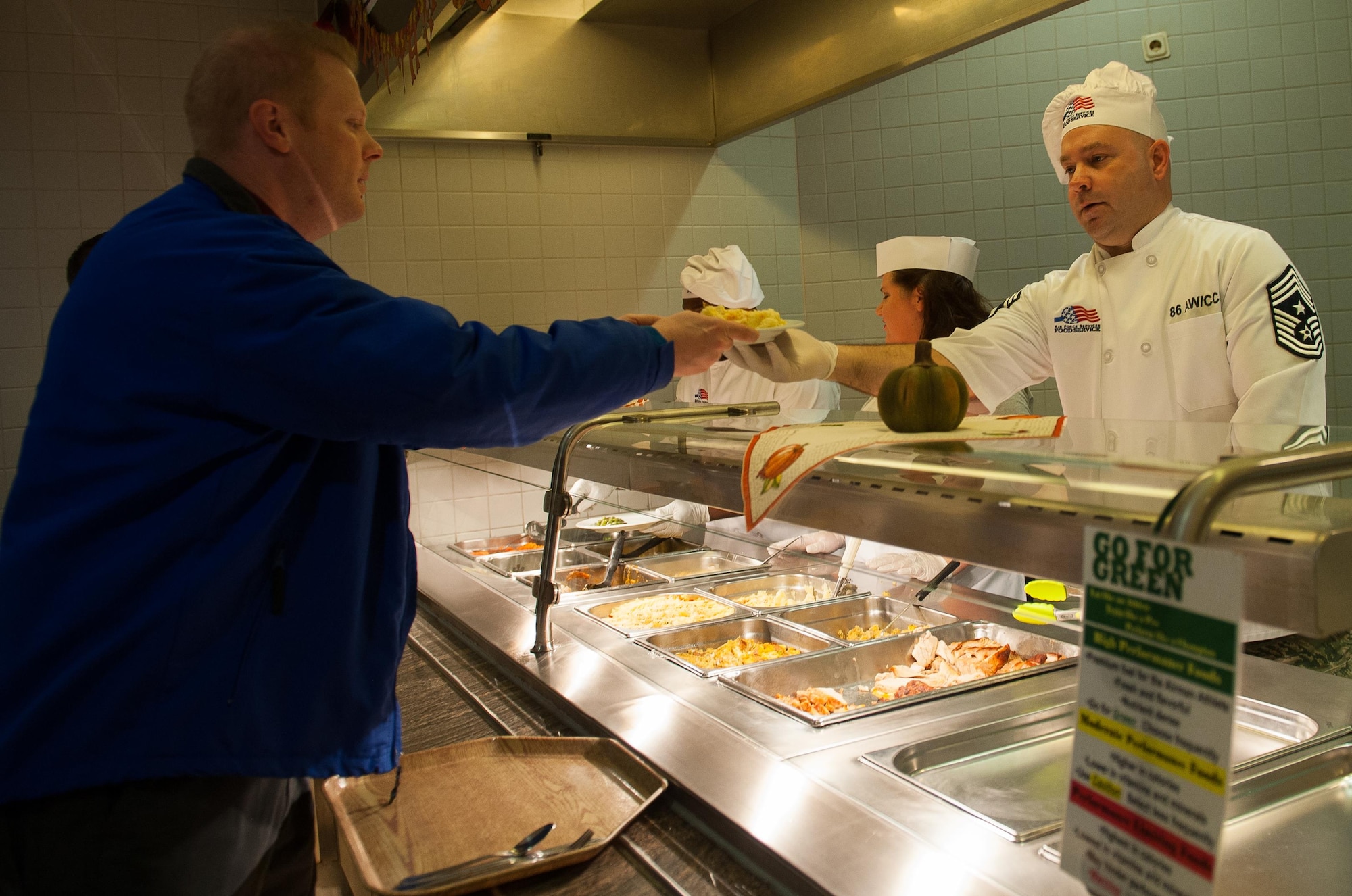 Chief Master Sgt. Aaron Bennett, 86th Airlift Wing command chief, serves Airmen during a Thanksgiving meal at Ramstein Air Base, Germany, Nov. 24, 2016. Every year at Ramstein, leadership across the Kaiserslautern Military Community visits the base’s dining facility to cook food and meet Airmen during Thanksgiving. Menu items included turkey, prime rib, ham, mashed potatoes and dressing. In the U.S., the modern Thanksgiving holiday tradition can trace its origins back to 1621 in the heart of a newly-founded city called Plymouth in present-day Massachusetts. However, the first nationwide Thanksgiving proclamation was made by the first president of the U.S., George Washington, in 1789. Since then, the holiday has been celebrated by an entire nation to recount the blessings of the year. (U.S. Air Force photo by Airman 1st Class Lane T. Plummer)