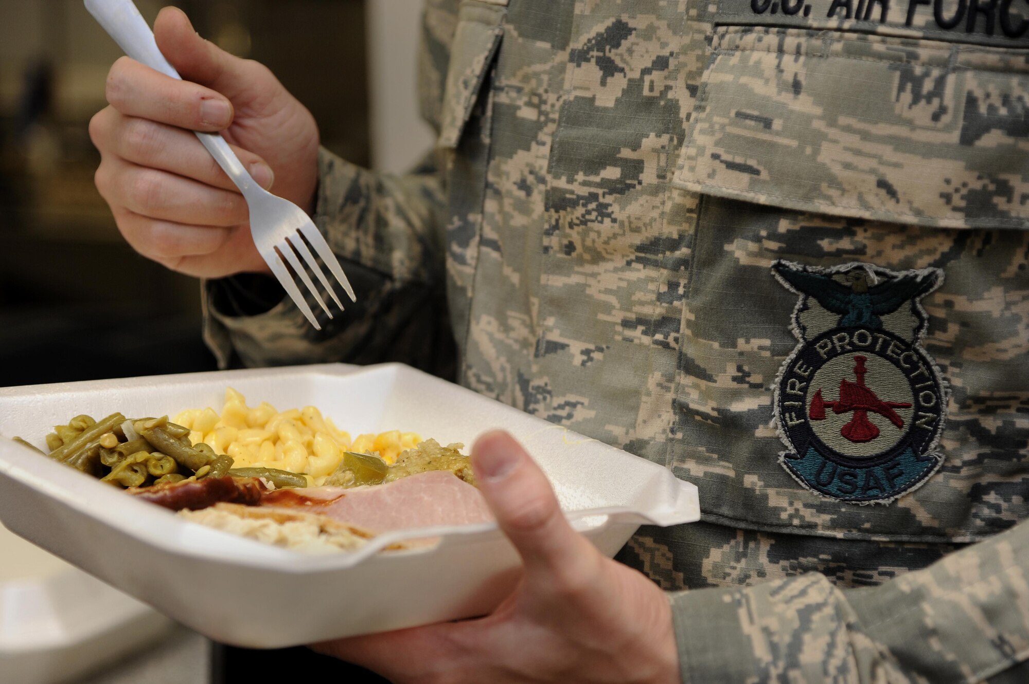Senior Airman Lowell Boozer, 2nd Civil Engineer Squadron fire protection journeyman, gets ready to eat his Thanksgiving Day meal at the fire station on Barksdale Air Force Base, La., Nov. 24, 2016. Fire protection is one of many squadrons across Barksdale that is required to have 24 hour operations at all times. (U.S. Air Force illustration/Staff Sgt. Joseph A. Pagán Jr.)