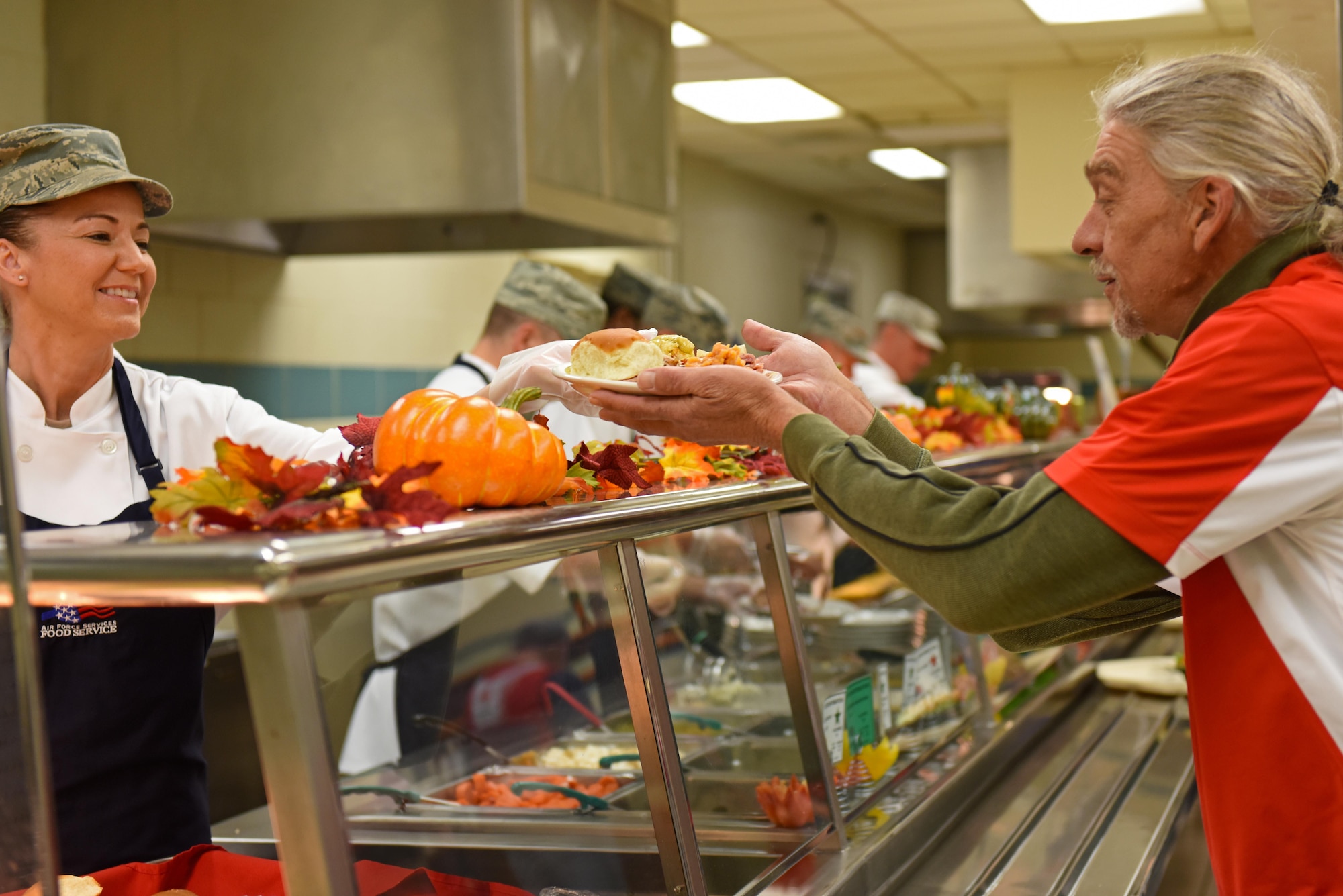 Senior Master Sgt. Tammy Moore, 4th Comptroller Squadron superintendent, hands a Red Cross volunteer a plate of food at the dining facility at Seymour Johnson Air Force Base, North Carolina, Nov. 24, 2016. Team Seymour leadership and 4th Force Support Squadron Airmen gave back to the Red Cross volunteers and staff members by providing a tour of the base and serving a hot Thanksgiving meal. (U.S. Air Force photo by Airman 1st Class Ashley Williamson)