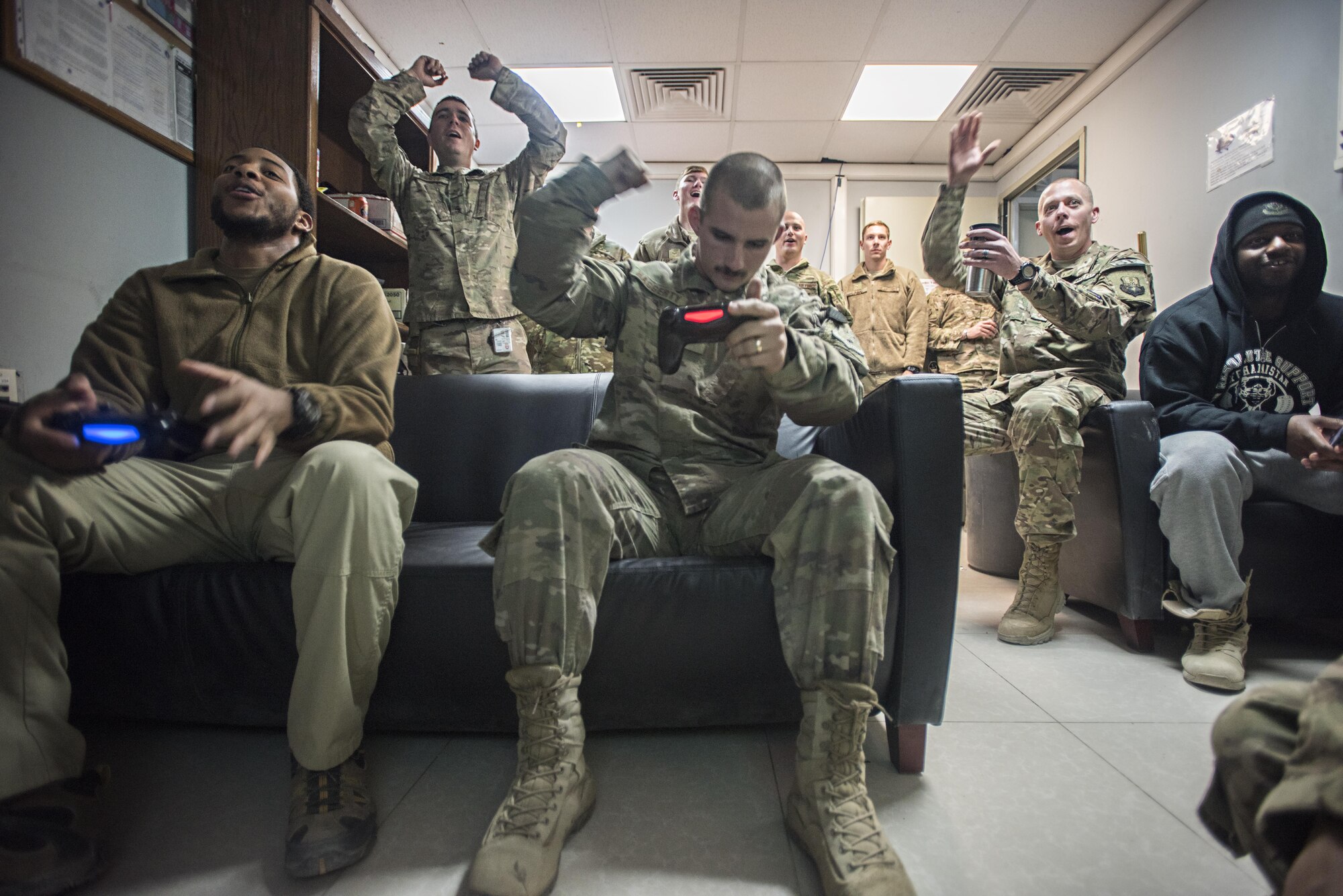 Members of the 455th Expeditionary Security Forces Squadron cheer during the final match of a Madden tournament on Thanksgiving, Nov. 24, 2016 at Bagram Airfield, Afghanistan. Service members around Bagram celebrated the holiday away from home with games, food and camaraderie. (U.S. Air Force photo by Staff Sgt. Katherine Spessa)
