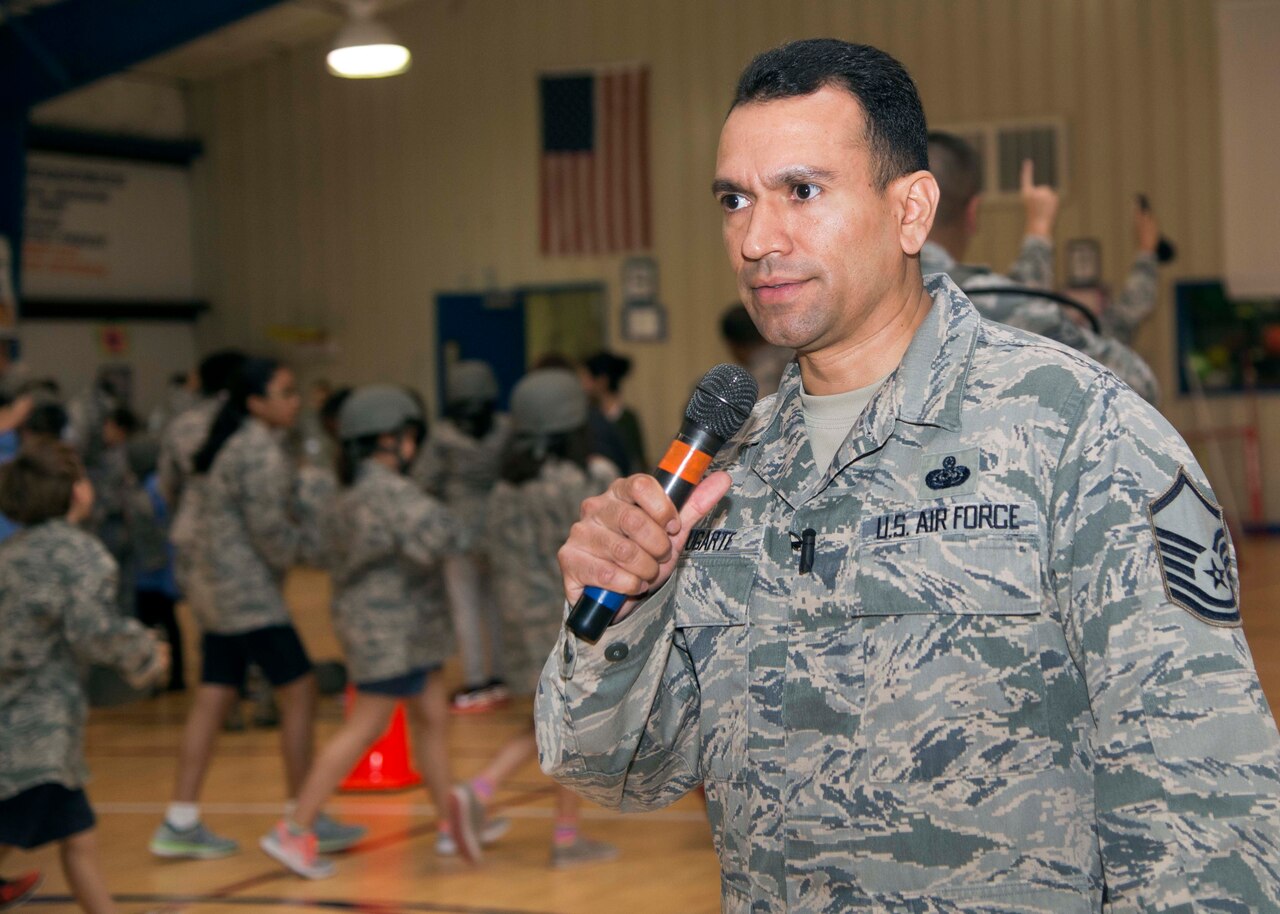 Air Force Master Sgt. Joe Ugarte, 802nd Force Support Squadron Military Family Readiness Center readiness noncommissioned officer, gives instructions during Operation FLAGS, which stands for Families Learning About Global Support, at Randolph Elementary School at Joint Base San Antonio-Randolph, Texas, May 18, 2016. About 300 third-, fourth- and fifth-graders from Randolph Elementary School accomplished a special "mission" where they experienced what it's like for their active-duty parents to leave for a deployment. Courtesy photo
