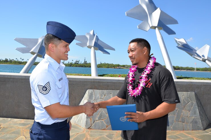 Tech. Sgt. Michael Shinohara, an Air Force Reserve recruiter based out of Joint Base Pearl Harbor-Hickam, and a Yigo, Guam native, congratulates Adrian Faustino after he signed his oath of enlistment at the Missing Man Formation, JBPH-H, Hawaii, Nov. 10, 2016. Faustino, who plans to join the 48th Aerial Port Squadron as an Air Transportation specialist, was referred by a reservist who used the Get 1 Now app. Located on Oahu and a component of the Air Force Reserve, the 48th APS provides expertise in all areas of air terminal operations to include aircraft loading, cargo processing and inspecting, passenger services, aircraft fleet services and aerial port command and control. The 48th APS supports the 624th Regional Support Group's mission to deliver mission essential capability through combat readiness, quality management and peacetime deployments in the Pacific area of responsibility. (U.S. Air Force photo by Master Sgt. Theanne Herrmann) 