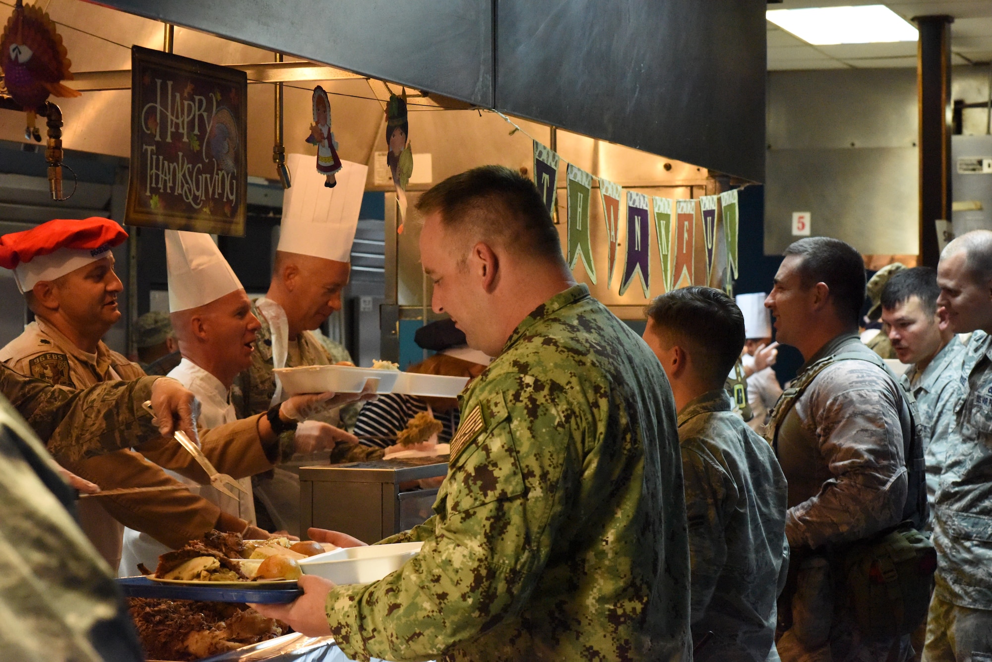 Senior leaders with the 379th Air Expeditionary Wing team up with the 379th Expeditionary Force Support Squadron dining facility team to serve Thanksgiving lunch and dinner at Al Udeid Air Base, Qatar, Nov. 24, 2016. In celebration of the holiday, the dining facility prepared a special feast for lunch and dinner that included many traditional Thanksgiving dishes. (U.S. Air Force photo by Senior Airman Cynthia A. Innocenti)
