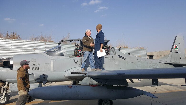 A maintenance contractor shakes hands with an Afghan Air Force aircraft maintainer on the wing of an A-29 Super Tucano at Hamid Karzai International Airport, Kabul, Afghanistan, Nov. 23, 2016. AAF maintainers recently conducted the first 600-hour aircraft inspection of an A-29. The maintainers were able to complete the three-week inspection with minimal assistance from contractors. (U.S. Air Force photo by Tech. Sgt. Jeffery Marino)