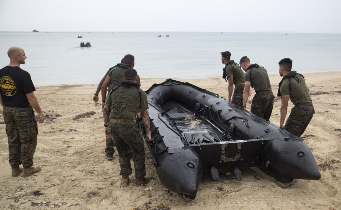 Marines from 3d Reconnaissance Battalion, 3d Marine Division, III Marine Expeditionary Force, carry a rubber inflatable raft into the water to begin the “boating” station on Camp Schwab, Okinawa, Japan, Nov. 23, 2016, during their annual Warrior Challenge. This event honors fallen Marines in the battalion and consists of nine stations to challenge the Marines mentally and physically. (U.S. Marine Corps photo by Lance Cpl. Andrew Neumann/Released)