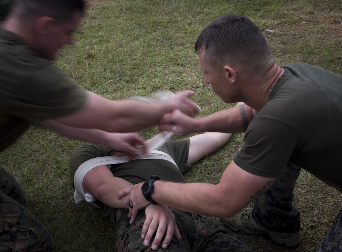 Marines from 3d Reconnaissance Battalion, 3d Marine Division, III Marine Expeditionary Force, wrap a victim's arm during the “medical” station on Camp Schwab, Okinawa, Japan, Nov. 23, 2016, during their annual Warrior Challenge. This event honors fallen Marines in the battalion and consists of nine stations to challenge the Marines mentally and physically. (U.S. Marine Corps photo by Lance Cpl. Andrew Neumann/Released)