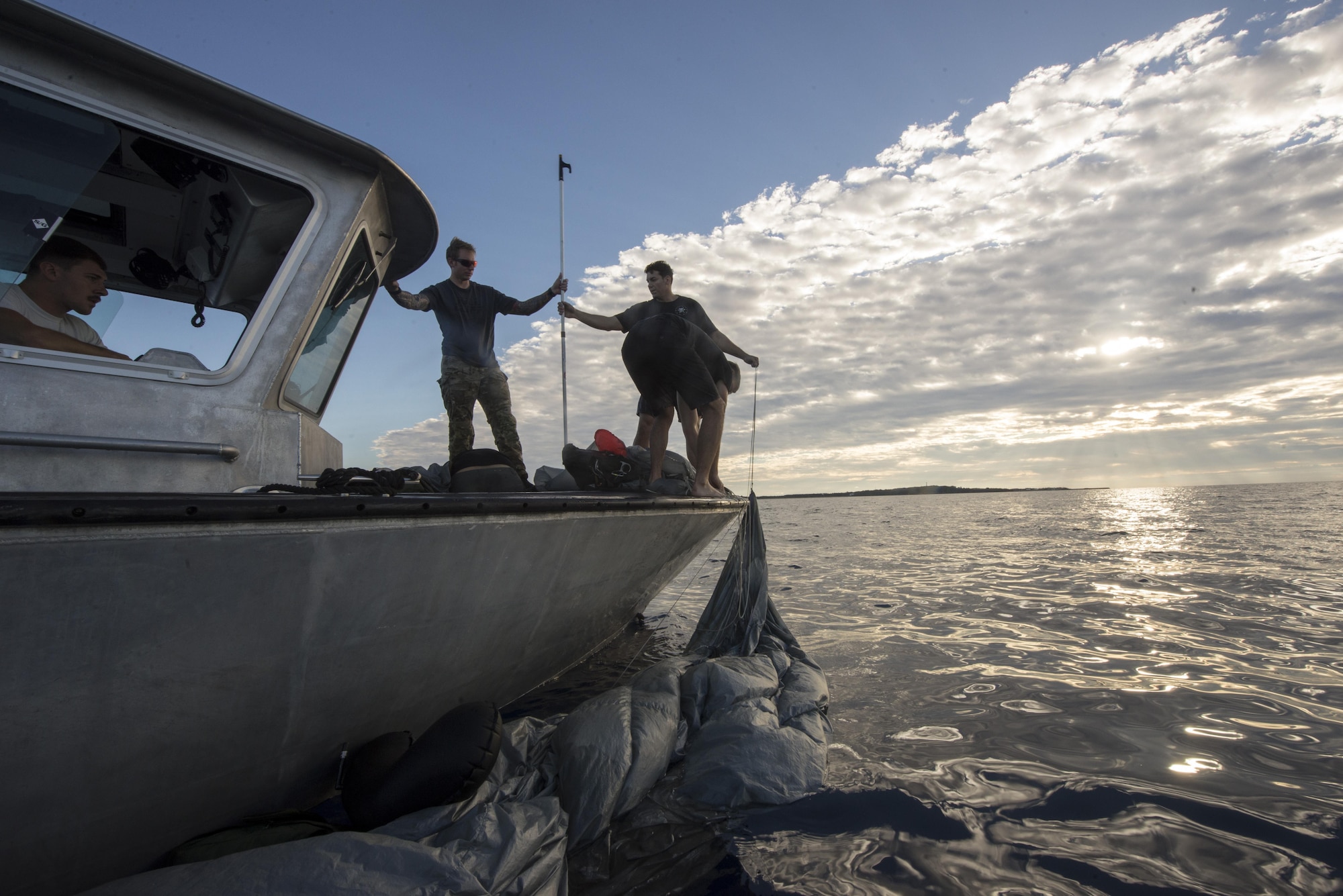 U.S. Air Force Airmen from the 320th Special Tactics Squadron retrieve parachutes form the water after a long-range jump from a C-17 Globemaster III into the Pacific Ocean Nov. 22, 2016, off the western coast of Okinawa, Japan. Once wet, the Airmen have 48-hours to dry and wash their parachutes to maintain serviceability. (U.S. Air Force photo by Senior Airman Omari Bernard/Released)