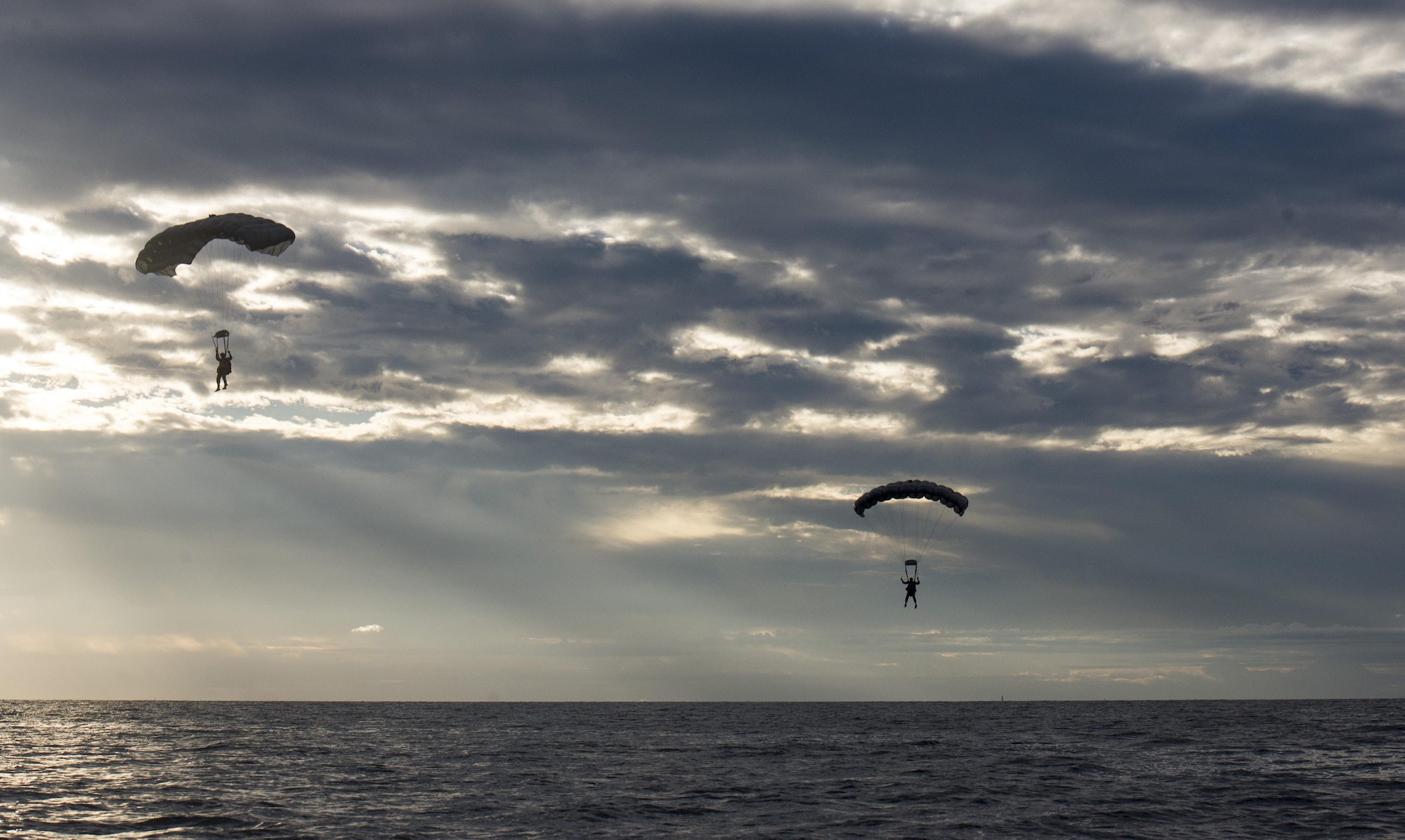 U.S. Air Force Airmen from the 320th Special Tactics Squadron at Kadena Air Base, Japan, parachute into the Pacific Ocean at dawn Nov. 22, 2016, off the western coast Okinawa, Japan. The 320th STS Airmen train to operate in adverse conditions at sea or overland to accomplish their mission. (U.S. Air Force photo by Senior Airman Omari Bernard/Released)