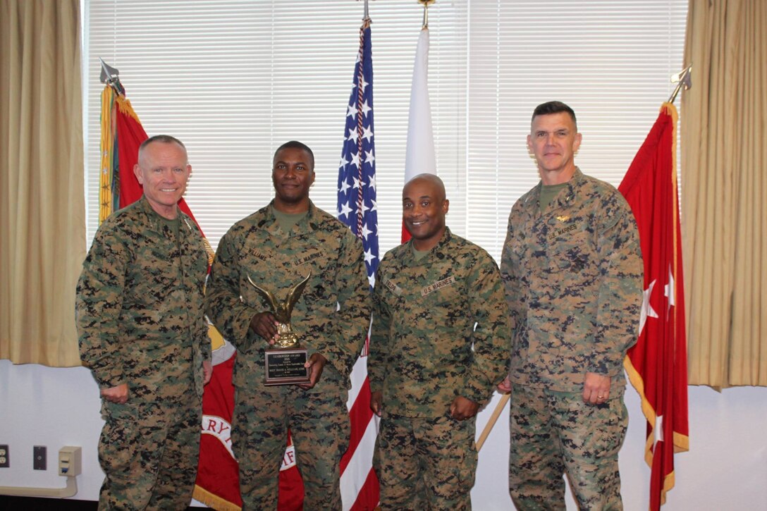 Marine Master Sgt. Travis A. Williams receives the 2015 Navy and Marine Association Leadership Award November 18, 2015 in Okinawa, Japan. This award is an annual award given to the most outstanding company grade officers and enlisted Marines and Sailors at each regiment/group or headquarters-level unit within the operating forces. Williams, an East Orange, New Jersey native, is a communications chief with 3d Marine Expeditionary Brigade, III Marine Expeditionary Force.  Master Sgt. Williams (second from the left) received the award from Lt. Gen. Lawrence D. Nicholson (far left), Commanding General, III Marine Expeditionary Force.  They are accompanied here by Sgt. Maj. Mario P. Fields (second from the right), Sergeant Major, III MEF Headquarters Group, and Brig. Gen. John M. Jansen (far right), Commanding General, 3d Marine Expeditionary Brigade/Deputy Commanding General, III Marine Expeditionary Force. (Courtesy Photo)