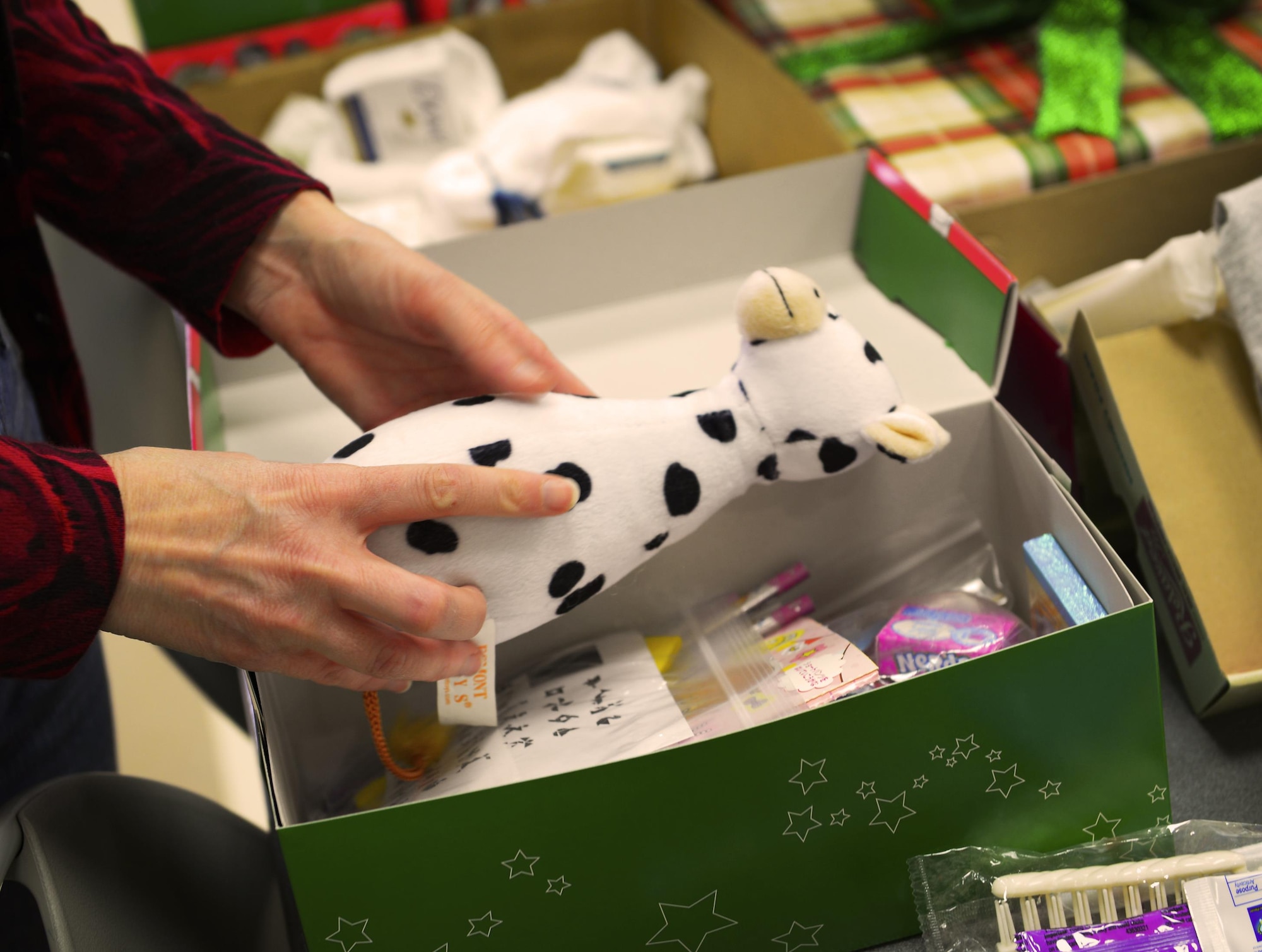 Drew Jernigan, coordinator for Yokota’s Operation Christmas Child initiative, packs a gift box at Yokota Air Base, Japan, Nov. 10, 2016. Every year Jernigan and her daughter, Emma Grace, collect toys, school supplies, hygiene items and more to pack in shoe boxes and send to disadvantaged children all over the world. (U.S. Air Force photo by Airman 1st Class Elizabeth Baker/Released)