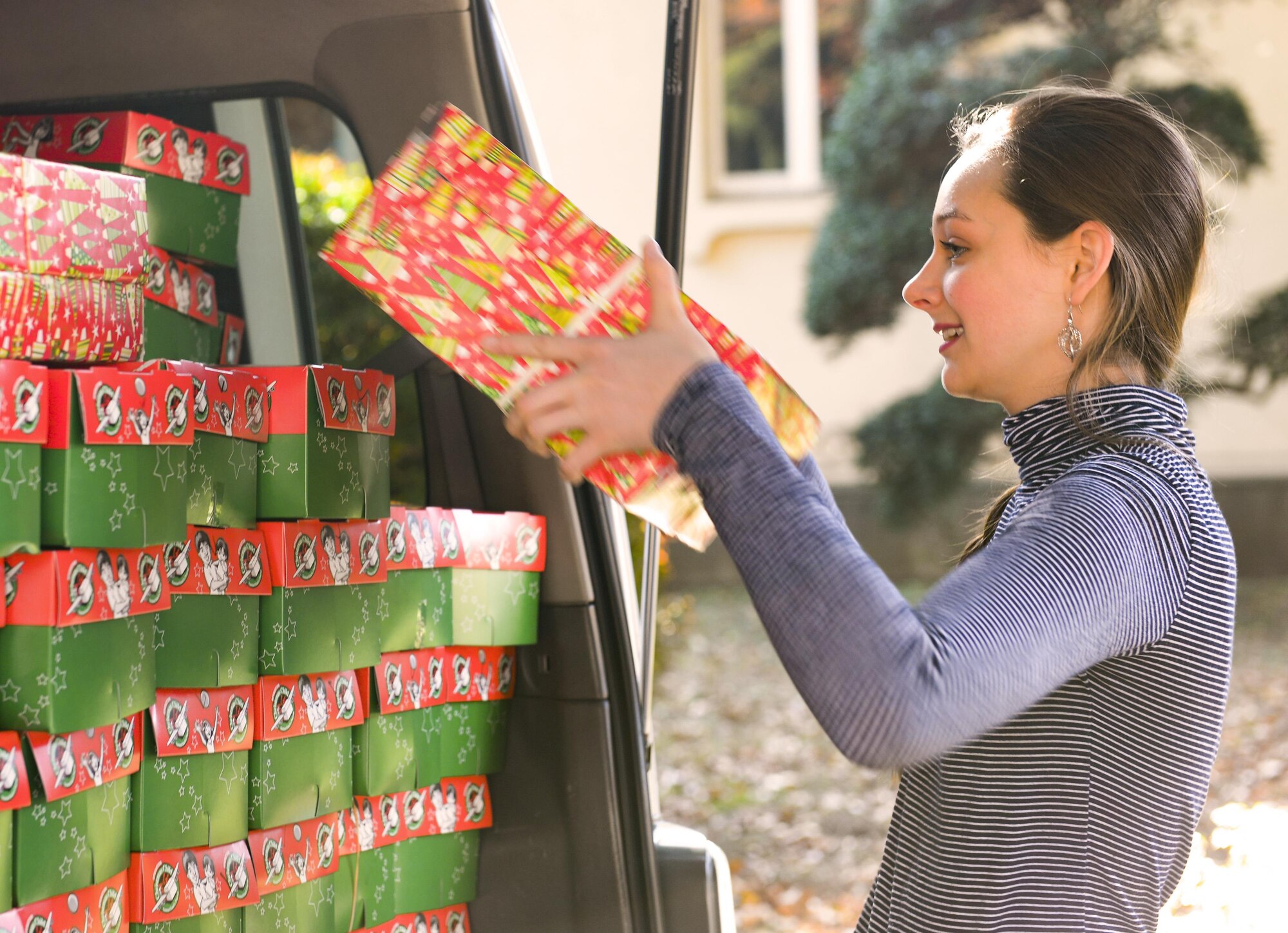 Hunter Grace Jernigan, coordinator for Yokota’s Operation Christmas Child initiative, loads gifts into a van at Yokota Air Base, Japan, Nov. 10, 2016. Every year Jernigan and her mother, Drew, collect toys, school supplies, hygiene items and more to pack in shoe boxes and send to disadvantaged children all over the world and are a popular way to give back during the holiday season. (U.S. Air Force photo by Airman 1st Class Elizabeth Baker/Released)