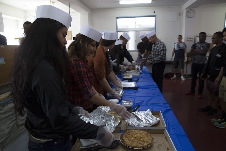Service members from Camp Kinser prepare to serve a special Thanksgiving meal to Okinawa patrons at the Promise Keepers Homeless Shelter Nov. 24 in Urasoe City, Okinawa, Japan. The event strengthened the relationship between service members and Okinawa residents by allowing them to serve the community directly. The vast array of dishes included roast turkey, ham, cranberry sauce and various pies. (U.S. Marine Corps photo by Cpl. Janessa K. Pon)