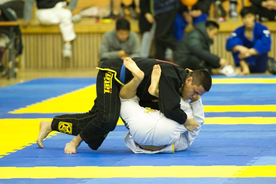 U.S. Air Force Senior Airman Kazuhito Ikematsu(top), 607th Support Squadron tactical satellite communications technician, rolls with Lee Won in an open weight blue belt Jiu-Jitsu match during the Dumau Jiu-Jitsu Korea Grand Prix 2016 in Seoul, Republic of Korea, Nov. 27, 2016. In addition to competing in the blue belt open weight class, Ikematsu also competed in the medium heavy weight class. (U.S. Air Force photo by Staff Sgt. Jonathan Steffen)
