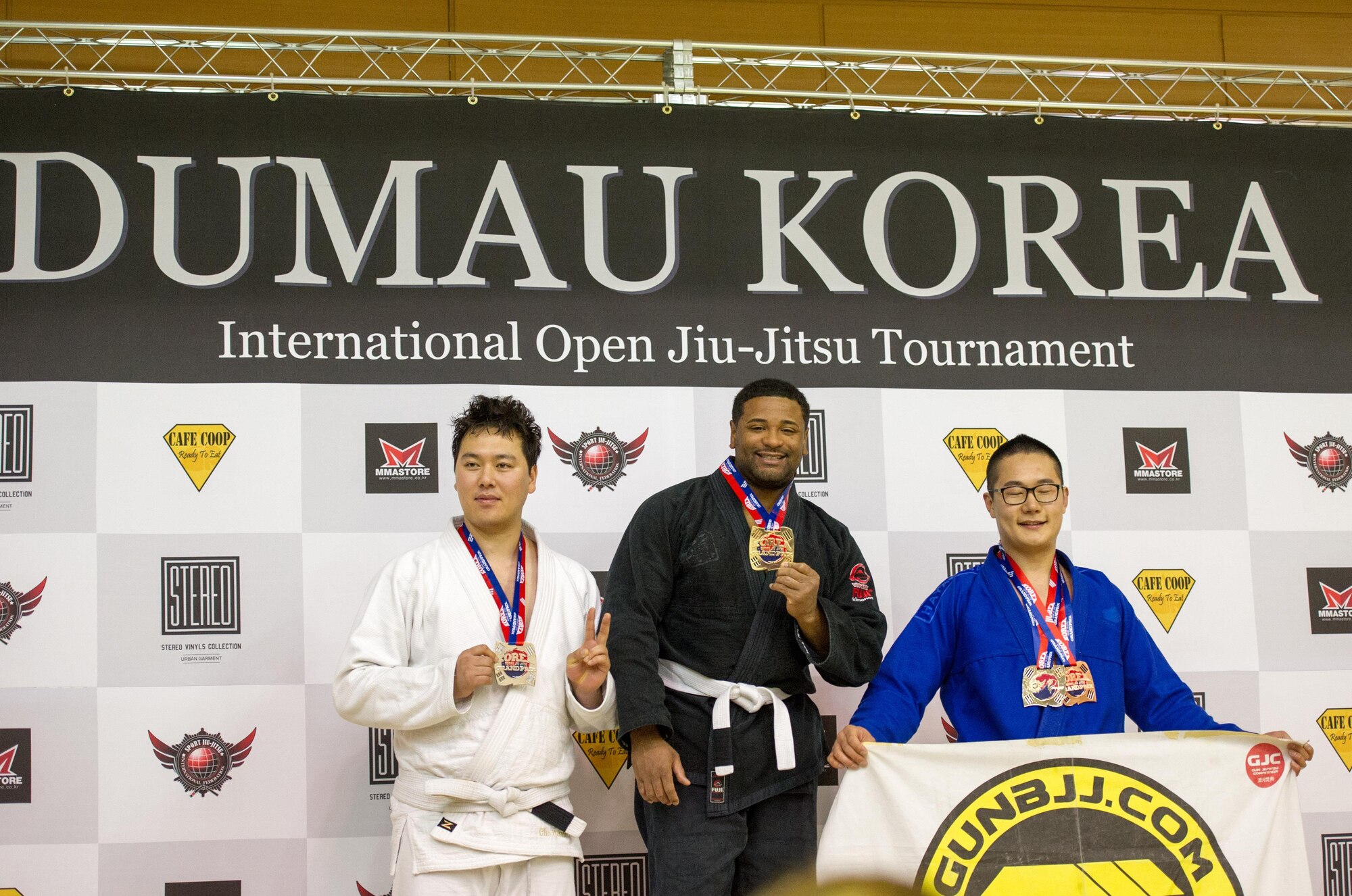 U.S. Air Force Staff Sgt. Brandon Davis (center), 51st Fighter Wing chaplain assistant, poses with his first place medal for master open weight white belt during the Dumau Jiu-Jitsu Korea Grand Prix 2016 in Seoul, Republic of Korea, Nov. 27, 2016. Davis won the master open weight white belt by beating 14 other competitors in a single-round eliminations competition. (U.S. Air Force photo by Staff Sgt. Jonathan Steffen)