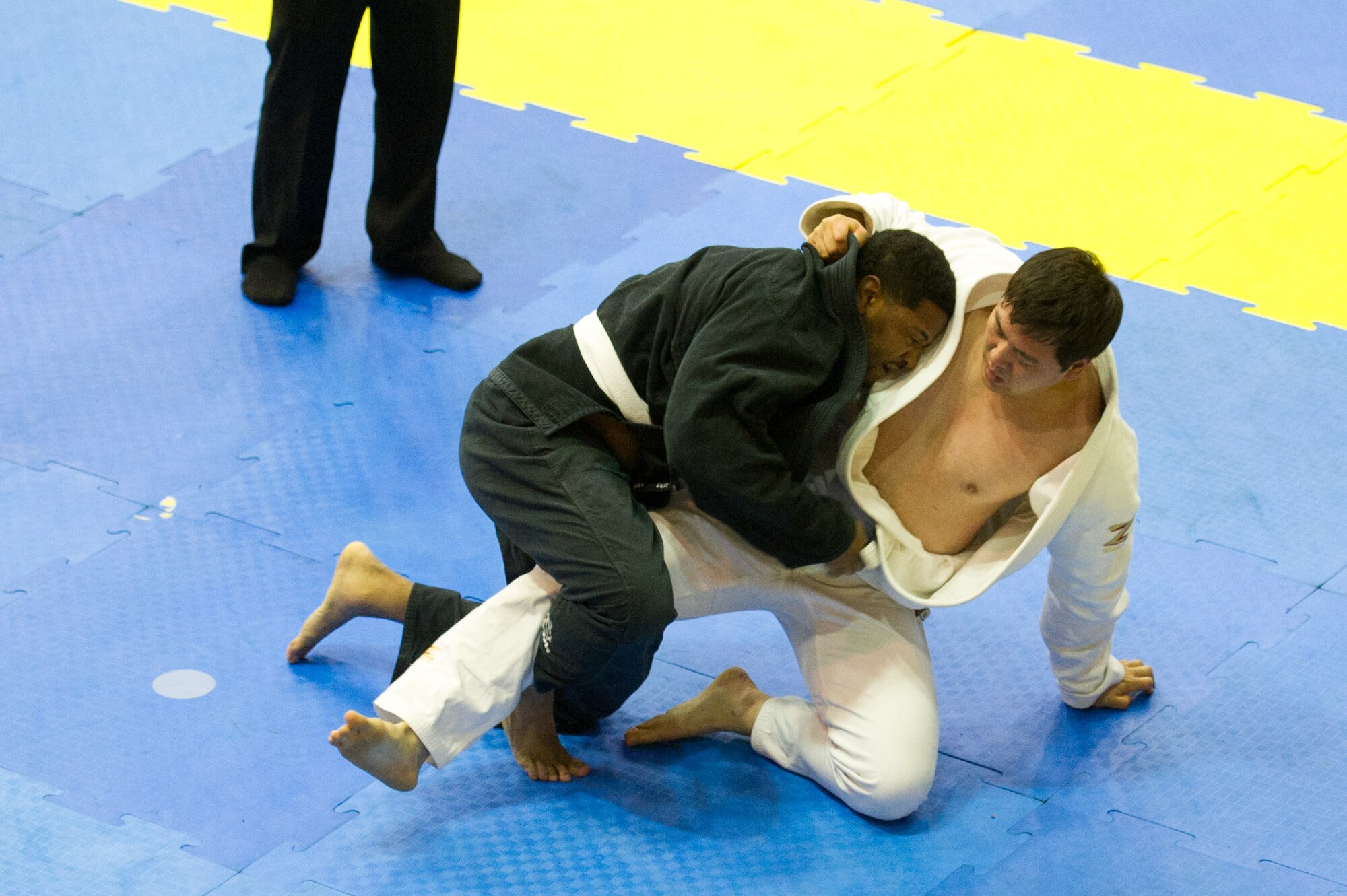 U.S. Air Force Staff Sgt. Brandon Davis, 51st Fighter Wing chaplain assistant, takes down Nam-Hyun Cho during a master ultra-heavy weight white belt Jiu-Jitsu match during the Dumau Jiu-Jitsu Korea Grand Prix 2016 in Seoul, Republic of Korea, Nov. 27, 2016. Davis won the master ultra-heavy white belt class and also won master open weight white belt class. (U.S. Air Force photo by Staff Sgt. Jonathan Steffen)