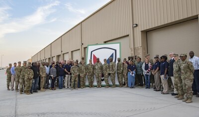 Service members and civilians gather for a group photo after a ribbon-cutting ceremony that celebrated the opening of several new equipment warehouses Nov. 17, 2016 at Camp Arifjan, Kuwait. The warehouses, designed and built by the U.S. Army engineers with the support of the Kuwait government, will store and protect Army equipment. (U.S. Army photo by Sgt. Angela Lorden)