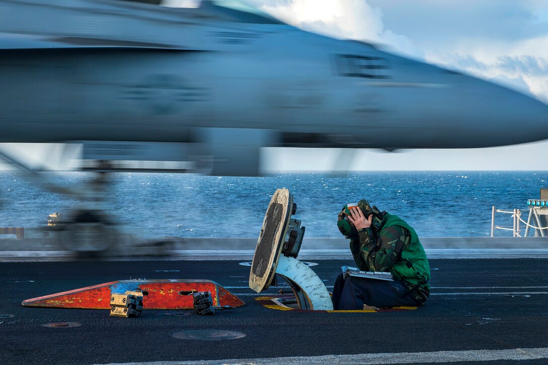 Navy Petty Officer 3rd Class Jesse Dowell stands the center deck operator watch as an F/A-18F Super Hornet launches from the flight deck of the aircraft carrier USS Carl Vinson in the Pacific Ocean, Nov. 21, 2016. Navy photo by Petty Officer 3rd Class Sean M. Castellano