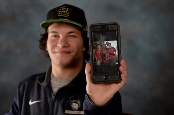 Zach Donnelly, son of the late Dave Donnelly, displays a family photo decked out in St. Louis Cardinals gear Nov. 4, 2016. Donnelly’s father passed away on Oct. 15 after a long battle with cancer. (U.S. Air Force photo by Airman 1st Class Denise M. Jenson)