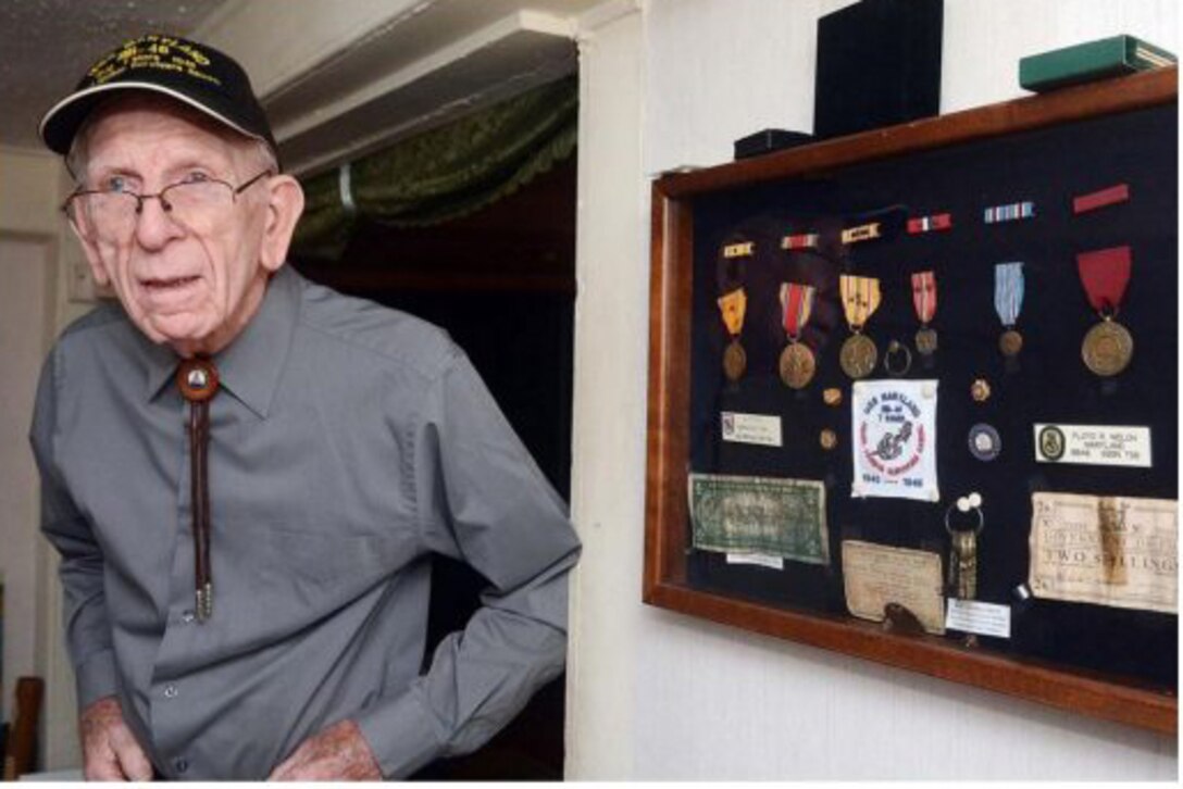 Pearl Harbor veteran Floyd Welch stands near his World War II medals at his home in East Lyme, Conn., Dec. 2014. Photo courtesy John Shishmanian/NorwichBulletin.com
