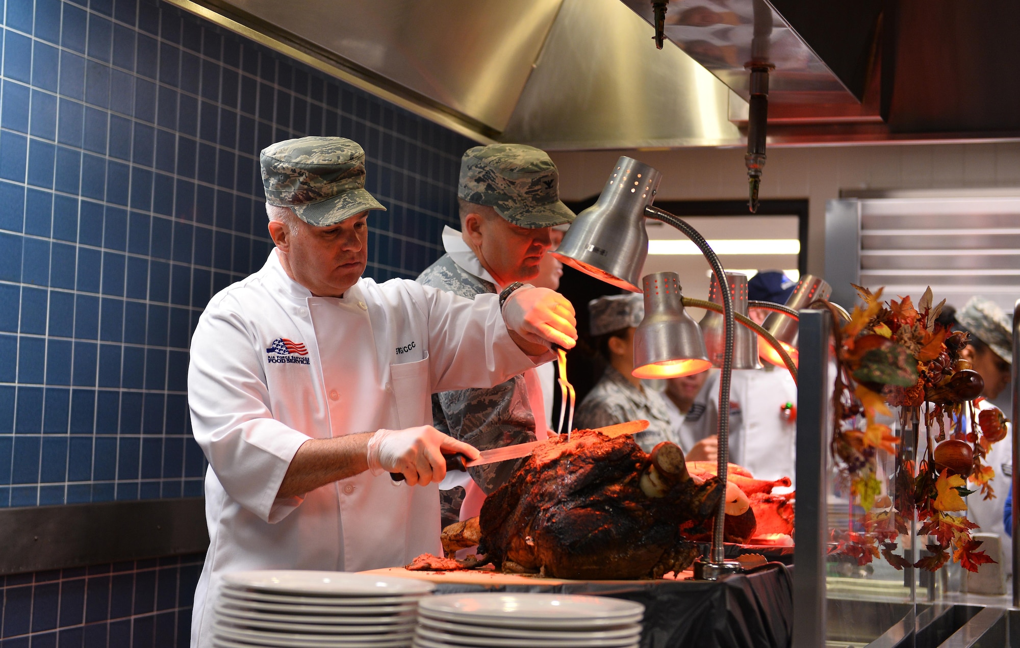 Chief Master Sgt. Michael A. Morris, 55th Wing command chief, cuts a roast at the Ronald L. King Dining Facility on Thanksgiving, Nov. 24, Offutt Air Force Base, Neb.  It’s an annual tradition for wing leadership to serve Airmen Thanksgiving dinner at the dining facility.  (U.S. Air Force photo by Josh Plueger)