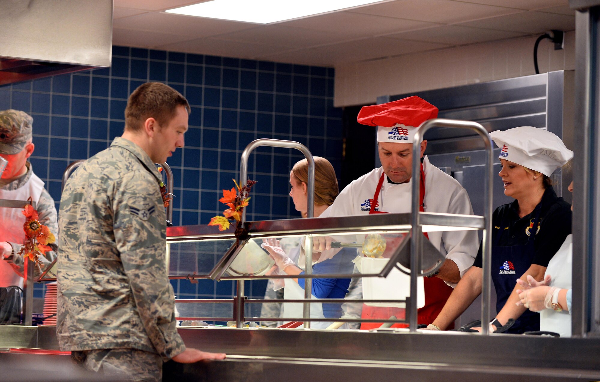 Col. Marty Reynolds, 55th Wing commander, along with his wife, Deanna help to serve Airmen Thanksgiving dinner at the Ronald L. King Dining Facility, Nov. 24, Offutt Air Force Base, Neb.  Wing and U.S. Strategic Command leadership and their families spent Thanksgiving afternoon greeting Airmen who celebrated the holiday on base.  (U.S. Air Force photo by Josh Plueger)