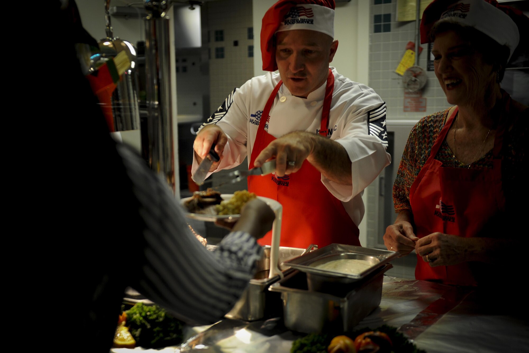 Chief Master Sgt. Anthony Cruz-Munoz, the command chief of the 1st Special Operations Wing, serves turkey to an Air Commando during a Thanksgiving meal at the Reef Dining Facility on Hurlburt Field, Fla., Nov. 24, 2016. The meal included turkey, ham, roast beef, mashed potatoes, shrimp cocktail, cranberries, corn and a selection of desserts.  (U.S. Air Force photo by Airman Dennis Spain)