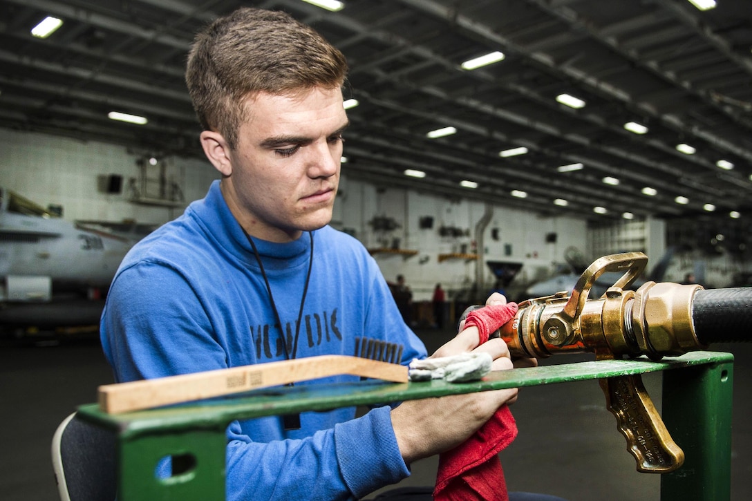 Navy Seaman Jared Lees polishes and cleans a vari-nozzle in the hangar bay of the aircraft carrier USS Dwight D. Eisenhower in the Persian Gulf, Nov. 24, 2016. Navy photo by Seaman Zach Sleeper