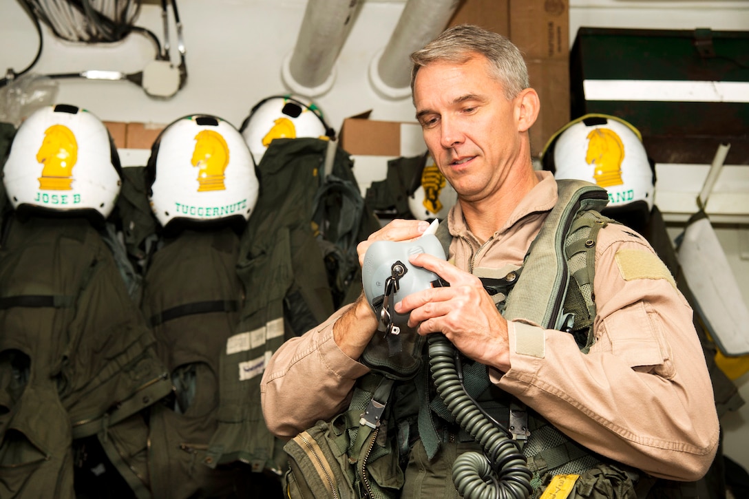 Navy Capt. Jeffrey Anderson, commander of Carrier Air Wing 3, disinfects his oxygen mask in the aircrew survival equipment room aboard the aircraft carrier USS Dwight D. Eisenhower, to prepare for flight operations in the Persian Gulf, Nov. 24, 2016. Navy photo by Petty Officer 3rd Class Nathan T. Beard