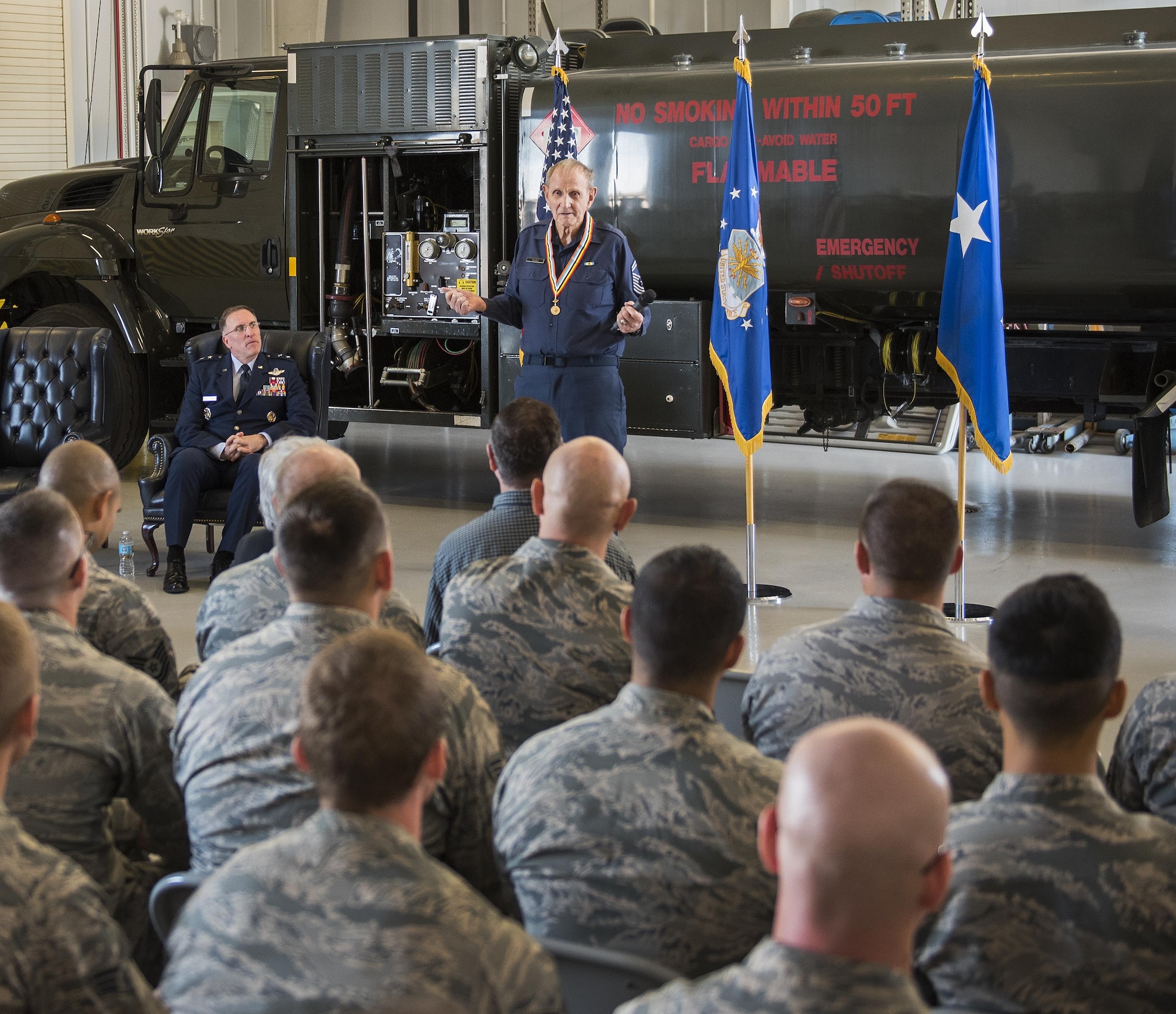 Retired Chief Master Sgt. Russell Rhodes speaks to an audience after receiving the Korean Ambassador for Peace Medal at Eglin Air Force Base, Fla., Nov. 15, 2016. The 85-year-old Rhodes requested the medal ceremony be held at the base’s fuels flight, where Rhodes was stationed during his Air Force career as a fuel truck driver. (U.S. Air Force photo/Samuel King Jr.)