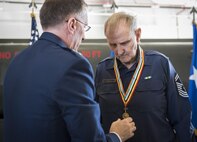 Maj. Gen. Scott Vander Hamm, the Air Force Assistant Deputy Chief of Staff, Operations, presents his uncle, retired Chief Master Sgt. Russell Rhodes, with a Korean Ambassador for Peace Medal during a ceremony held at Eglin Air Force Base, Fla., Nov. 15.  The ceremony was held at the base’s fuels flight, where Rhodes was stationed during his Air Force career as a fuel truck driver.  (U.S. Air Force photo/Samuel King Jr.)