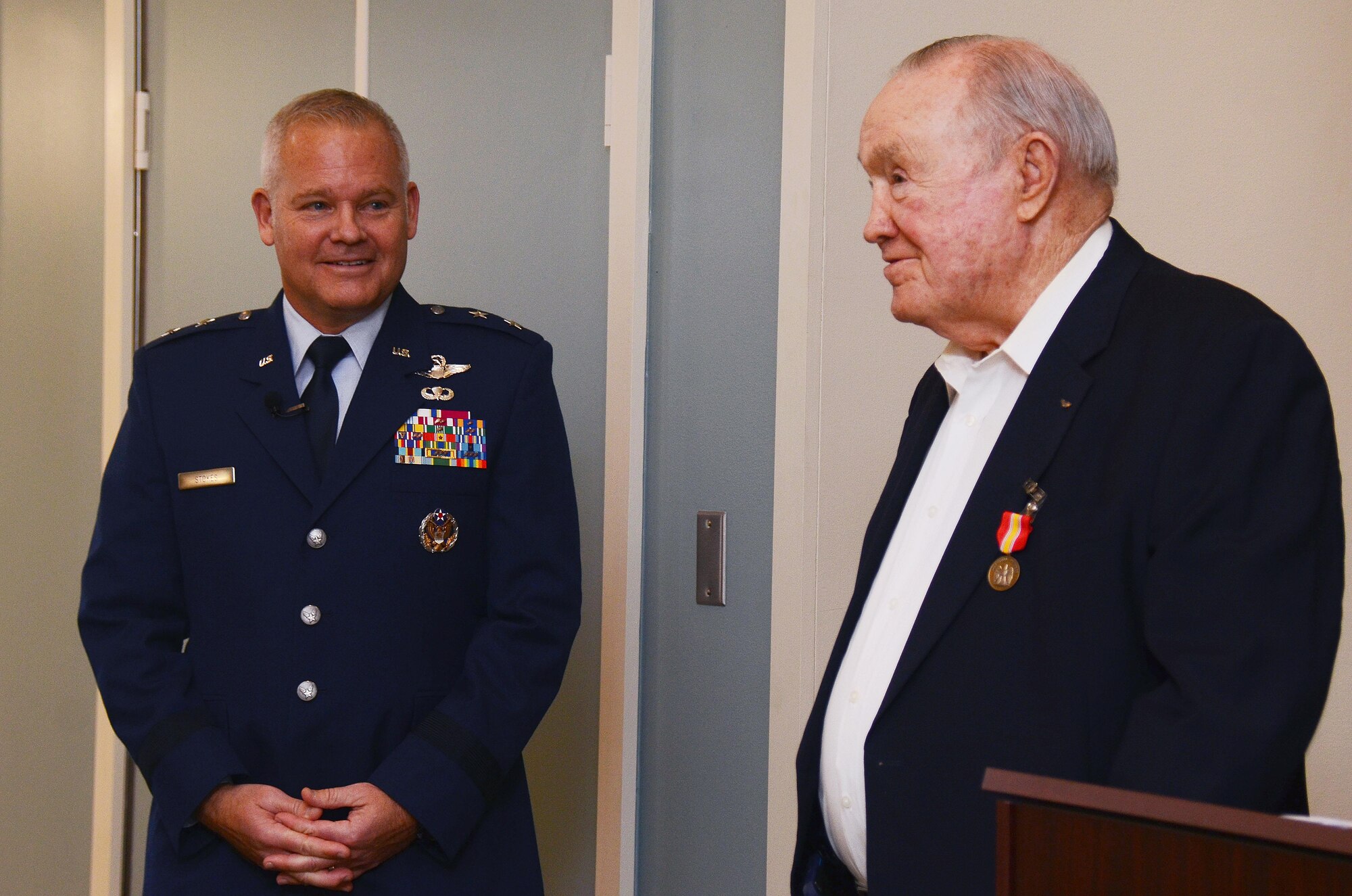 Maj. Gen. John Stokes, 22nd Air Force commander from Dobbins Air Reserve Base, Ga., looks on after presenting the National Defense Service Medal to former U.S. Air Force Capt. Stewart Graham for his service in the Korean War. Graham received the medal on Nov. 28, 2016 in the presence of family and friends 60 years after it was authorized. (U.S. Air Force photo/Don Peek)